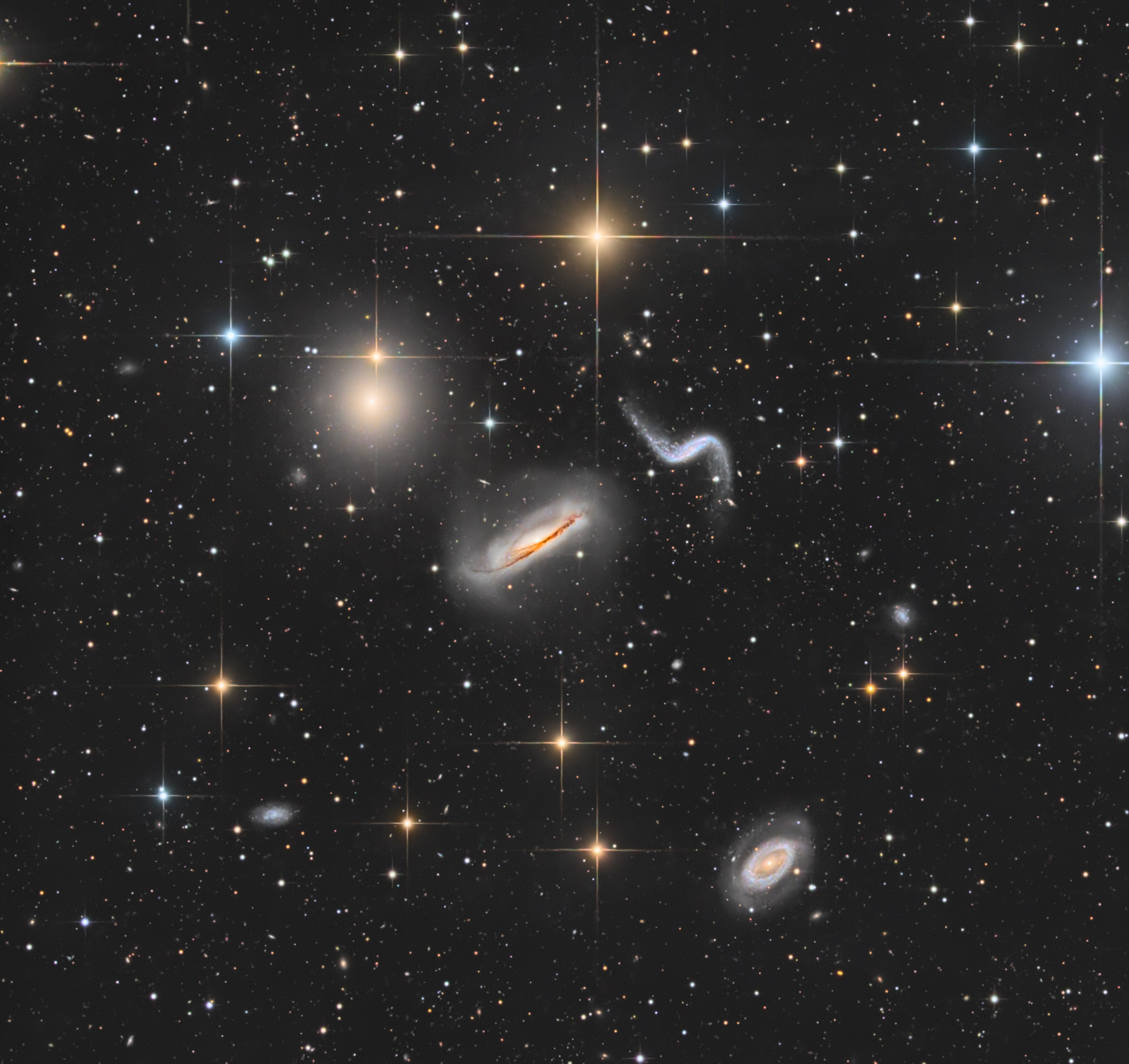 Scanning the skies for galaxies, Canadian astronomer Paul Hickson and colleagues identified some 100 compact groups of galaxies, now appropriately called Hickson Compact Groups. The four prominent galaxies seen in this intriguing telescopic skyscape are one such group, Hickson 44. The galaxy group is about 100 million light-years distant, far beyond the spiky foreground Milky Way stars, toward the constellation Leo. The two spiral galaxies in the center of the image are edge-on NGC 3190 with its distinctive, warped dust lanes, and S-shaped NGC 3187. Along with the bright elliptical, NGC 3193 (above and left) they are also known as Arp 316. The spiral toward the lower right corner is NGC 3185, the 4th member of the Hickson group. Like other galaxies in Hickson groups, these show signs of distortion and enhanced star formation, evidence of a gravitational tug of war that will eventually result in galaxy mergers on a cosmic timescale. The merger process is now understood to be a normal part of the evolution of galaxies, including our own Milky Way. For scale, NGC 3190 is about 75,000 light-years across at the estimated distance of Hickson 44.