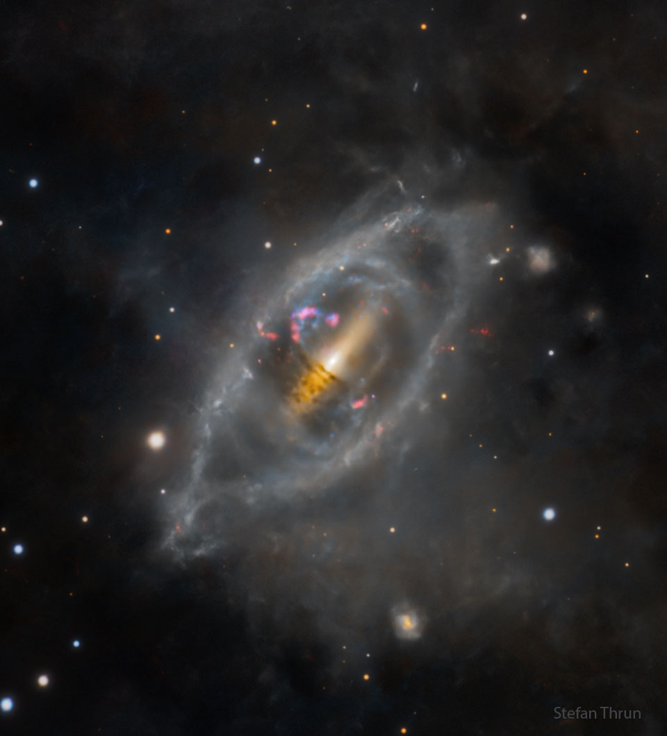 What is going on with this galaxy? NGC 2685 is a confirmed polar ring galaxy - a rare type of galaxy with stars, gas and dust orbiting in rings perpendicular to the plane of a flat galactic disk. The bizarre configuration could be caused by the chance capture of material from another galaxy by a disk galaxy, with the captured debris strung out in a rotating ring. Still, observed properties of NGC 2685 suggest that the rotating helix structure is remarkably old and stable. In this sharp view of the peculiar system also known as Arp 336 or the Helix galaxy, the strange, perpendicular rings are easy to trace as they pass in front of the galactic disk, along with other disturbed outer structures. NGC 2685 is about 50,000 light-years across and 40 million light-years away in the constellation of the Great Bear (Ursa Major).   Piece it All Together: Astronomy Puzzle of the Day