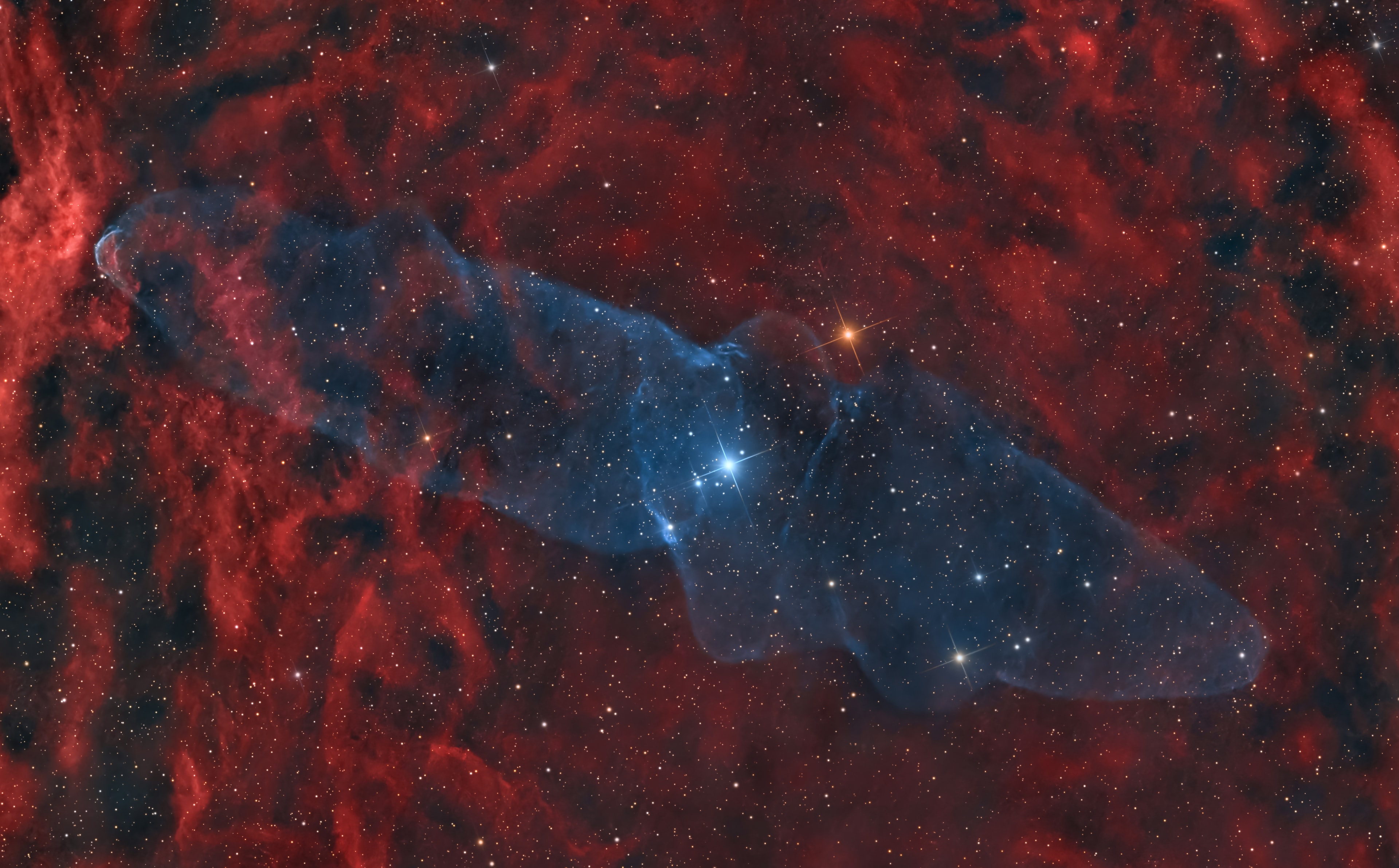 Difficult to capture, this mysterious, squid-shaped interstellar cloud spans nearly three full moons in planet Earth's sky. Discovered in 2011 by French astro-imager Nicolas Outters, the Squid Nebula's bipolar shape is distinguished here by the telltale blue emission from doubly ionized oxygen atoms. Though apparently surrounded by the reddish hydrogen emission region Sh2-129, the true distance and nature of the Squid Nebula have been difficult to determine. Still, one investigation suggests Ou4 really does lie within Sh2-129 some 2,300 light-years away. Consistent with that scenario, the cosmic squid would represent a spectacular outflow of material driven by a triple system of hot, massive stars, cataloged as HR8119, seen near the center of the nebula. If so, this truly giant squid nebula would physically be over 50 light-years across.