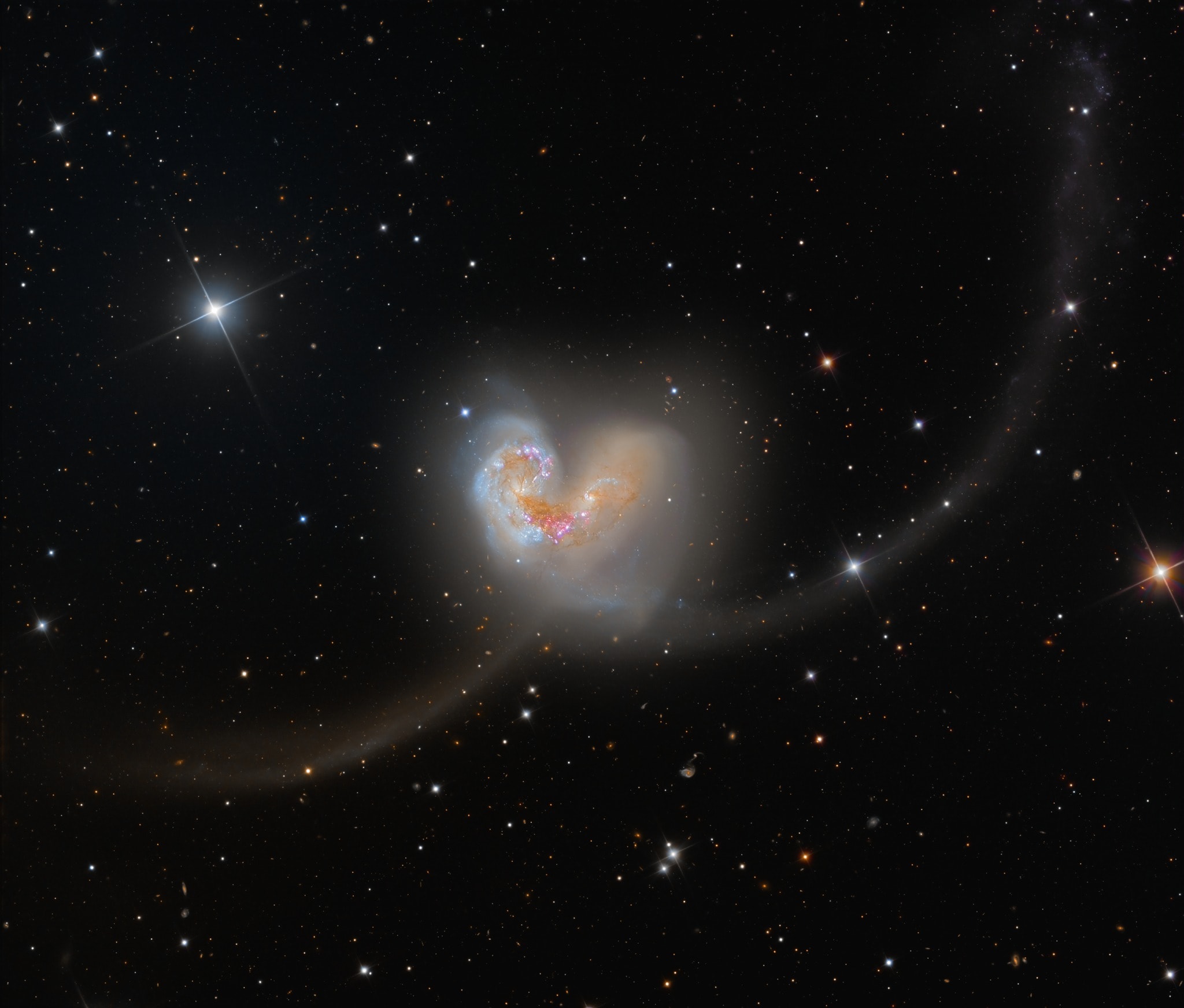 Some 60 million light-years away in the southerly constellation Corvus, two large galaxies are colliding. Stars in the two galaxies, cataloged as NGC 4038 and NGC 4039, very rarely collide in the course of the ponderous cataclysm that lasts for hundreds of millions of years. But the galaxies' large clouds of molecular gas and dust often do, triggering furious episodes of star formation near the center of the cosmic wreckage. Spanning over 50 thousand light-years, this stunning telescopic frame also reveals new star clusters and matter flung far from the scene of the accident by gravitational tidal forces. The remarkably sharp ground-based image follows the faint tidal tails and distant background galaxies in the field of view. The suggestive overall visual appearance of the extended arcing structures gives the galaxy pair, also known as Arp 244, its popular name - The Antennae.   Artemis II: mission updates