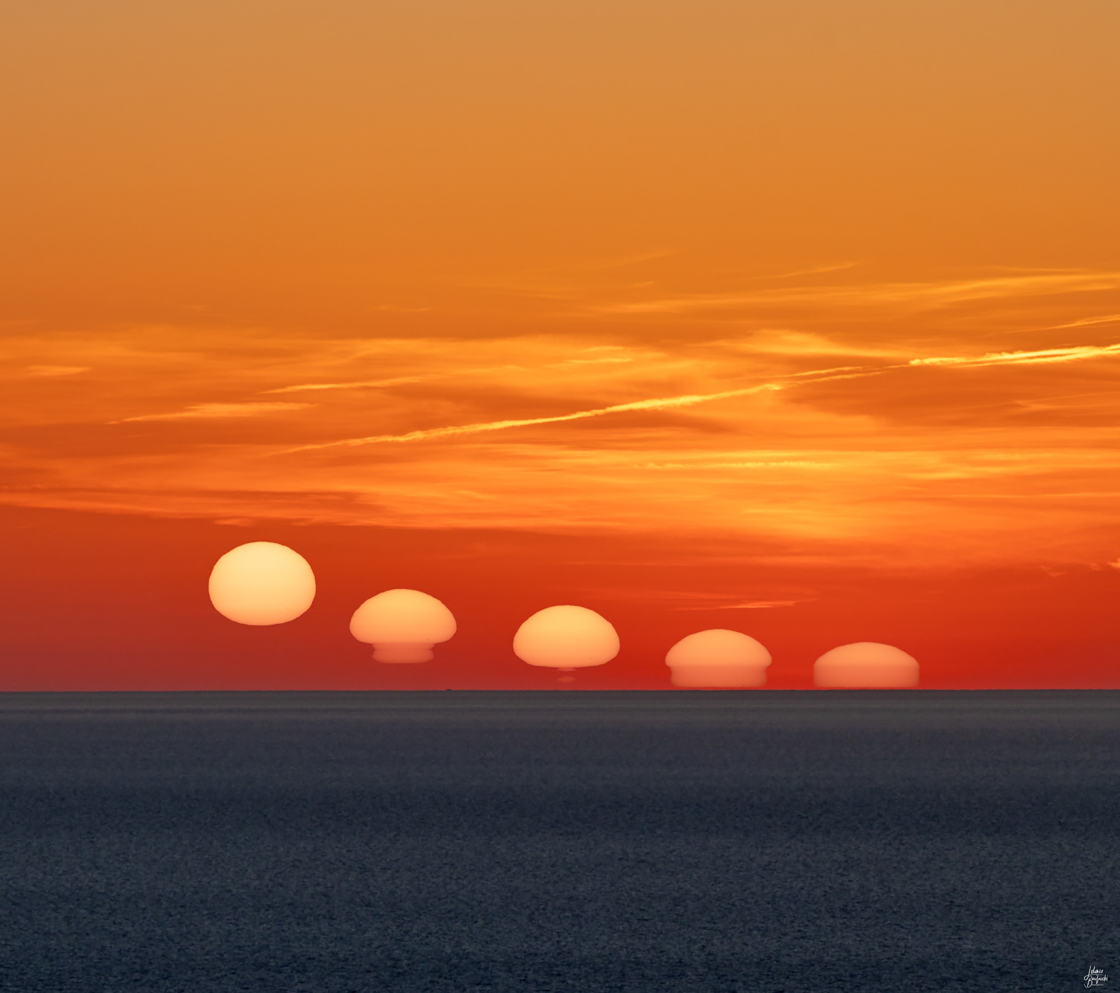 This seaside sunset offered a surreal experience, captured in a sea and skyscape from the west coast of Sardinia, Italy, planet Earth. The Daliesque scene is a composition of sequential exposures made with a camera and long telephoto lens. The Sun is not melting, though. Its shifting and fluid appearance as it nears the horizon is caused as refraction along the line of sight changes and creates distorted images or mirages of the reddened solar disk. The changes in atmospheric refraction correspond to atmospheric layers with sharply different temperatures and densities. Another famous but fleeting effect of atmospheric refraction produced by a long sight-line to the setting (or rising) Sun is often called the green flash.