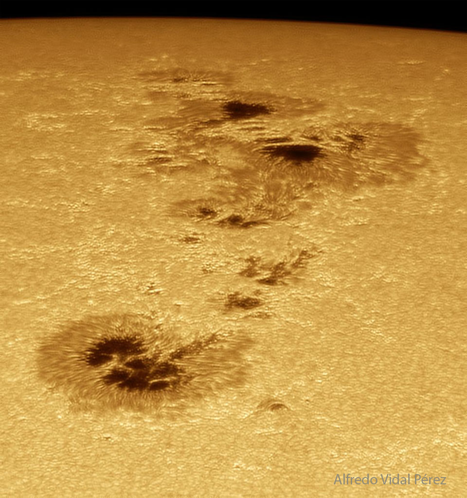 Right now, one of the largest sunspot groups in recent history is crossing the Sun.  Active Region 4478 is not only big -- it's violent, showing tangled magnetic fields capable of throwing off huge clouds of particles into the Solar System.  Some of these CMEs might impact the Earth.  At the extreme, these solar storms could cause some Earth-orbiting satellites to malfunction, the Earth's atmosphere to slightly distort, and electrical power grids to surge.  When impacting Earth's upper atmosphere, these particles can produce beautiful auroras. Pictured here, AR 4478 and its dark sunspots were captured in visible light a few days ago from Barcelona, Spain.  Almost as large as AR 3664 was in 2024, the AR 4478 sunspot group is so big that it is visible just with glasses specially designed to view solar eclipses.  This week, skygazing enthusiasts all over the globe will not only be tracking AR 4478 during the day -- but keenly watching night skies for its corresponding bright auroras.   Sky Surprise: What picture did APOD feature on your birthday? (after 1995)