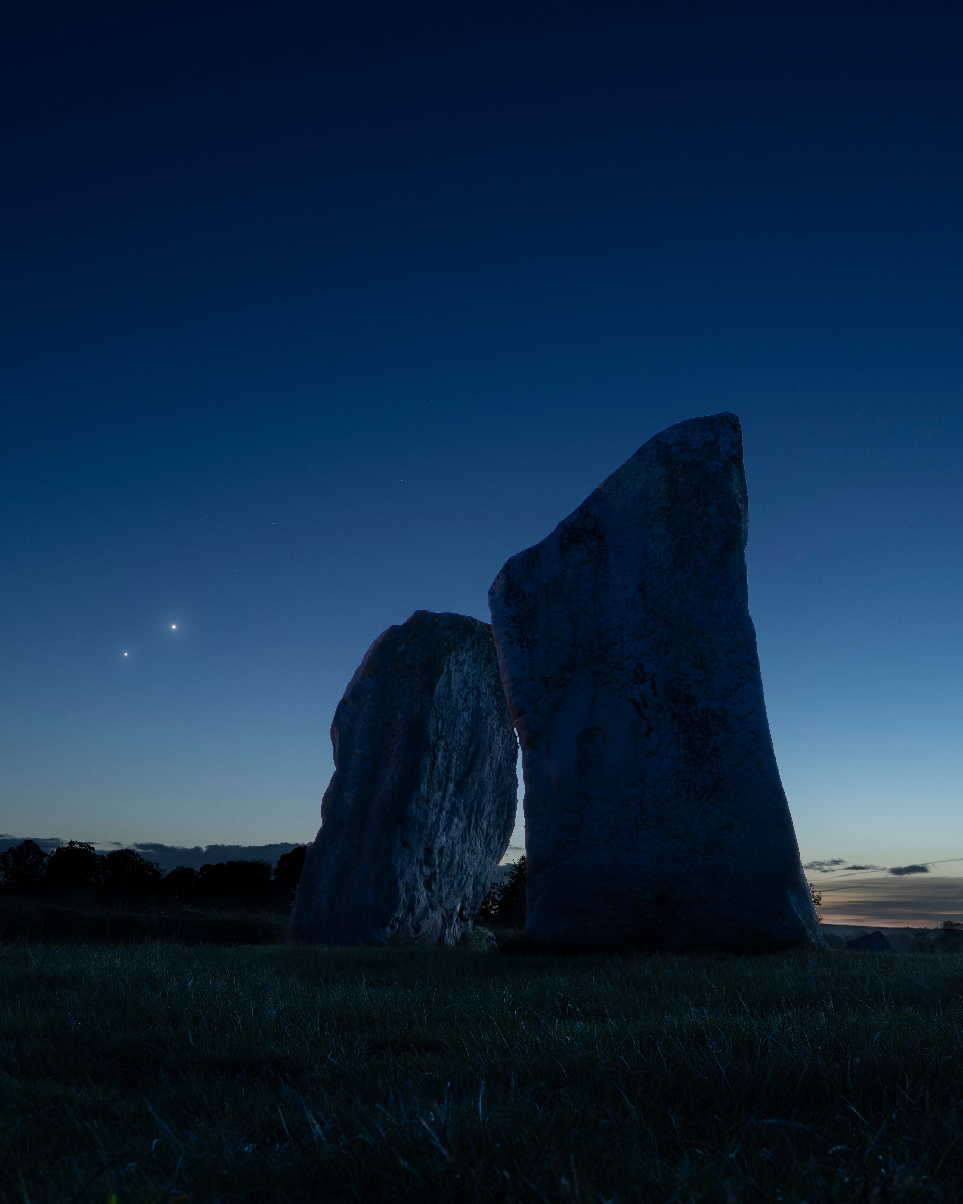 To see Venus and Jupiter together this month, you won't need binoculars or even a telescope. Just look up after sunset and you'll find them emerging as the sky grows dark near the western horizon. In fact, on June 9 the two brightest planets were in close conjunction, separated on the sky by less than 2 degrees from our perspective. Since (brighter) inner planet Venus orbits the Sun faster than outer planet Jupiter, it catches up with and passes the outer planet along the ecliptic roughly every 13 months. But every three years or so their resulting conjunction can be viewed far enough from the Sun to be easily seen in Earth's twilight skies. On June 9, the two celestial beacon's close "cosmic kiss" was captured here next to the two large standing stones at the cove within a 4,000 year old stone circle at Avebury, UK. Larger than Stonehenge, the Avebury henge and stone circle complex is also recognized as one of the most significant neolithic ceremonial sites on planet Earth.