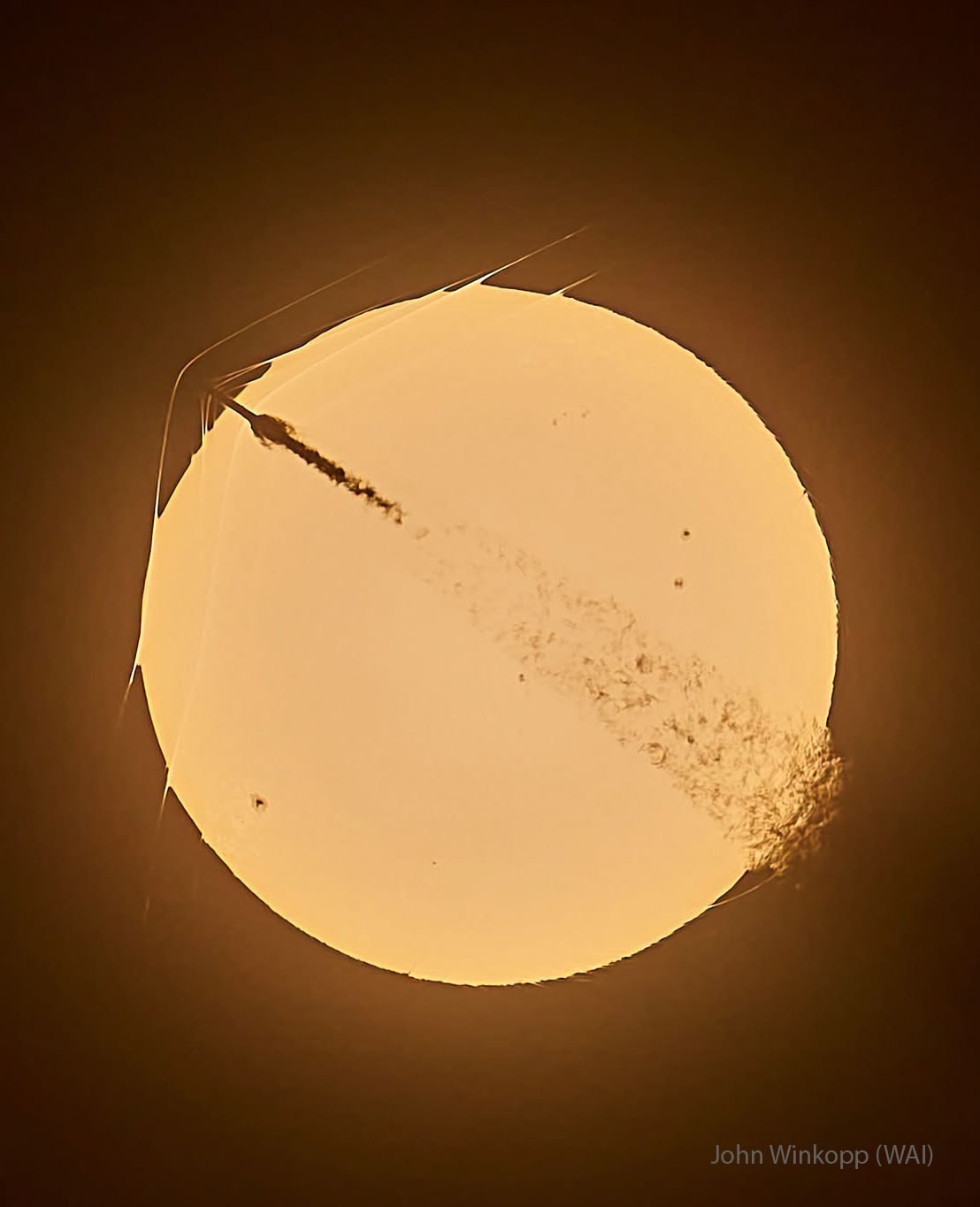 What's happening to this Sun-crossing rocket?  The SpaceX Falcon 9 rocket, visible on the upper left, launched only about one minute before this amazing image was captured.  As it rose to low Earth orbit from Cape Canaveral, Florida, USA,  in late May, the rocket became supersonic before it crossed the disk of the distant Sun -- from the perspective of the well-placed photographer.  The spacecraft's high speed caused bow-shaped compressed-air shockwaves to form across leading surfaces, with at least three visible even outside the Sun's disk because they refract sunlight.  The trailing exhaust caused turbulence visible on the lower right. None of this was damaging to the robotic Starlink 10-53 mission, which delivered 29 communications satellites to low Earth orbit as planned.  And if that isn't amazing enough - the Sun had spots!    Sky Surprise: What picture did APOD feature on your birthday? (after 1995)