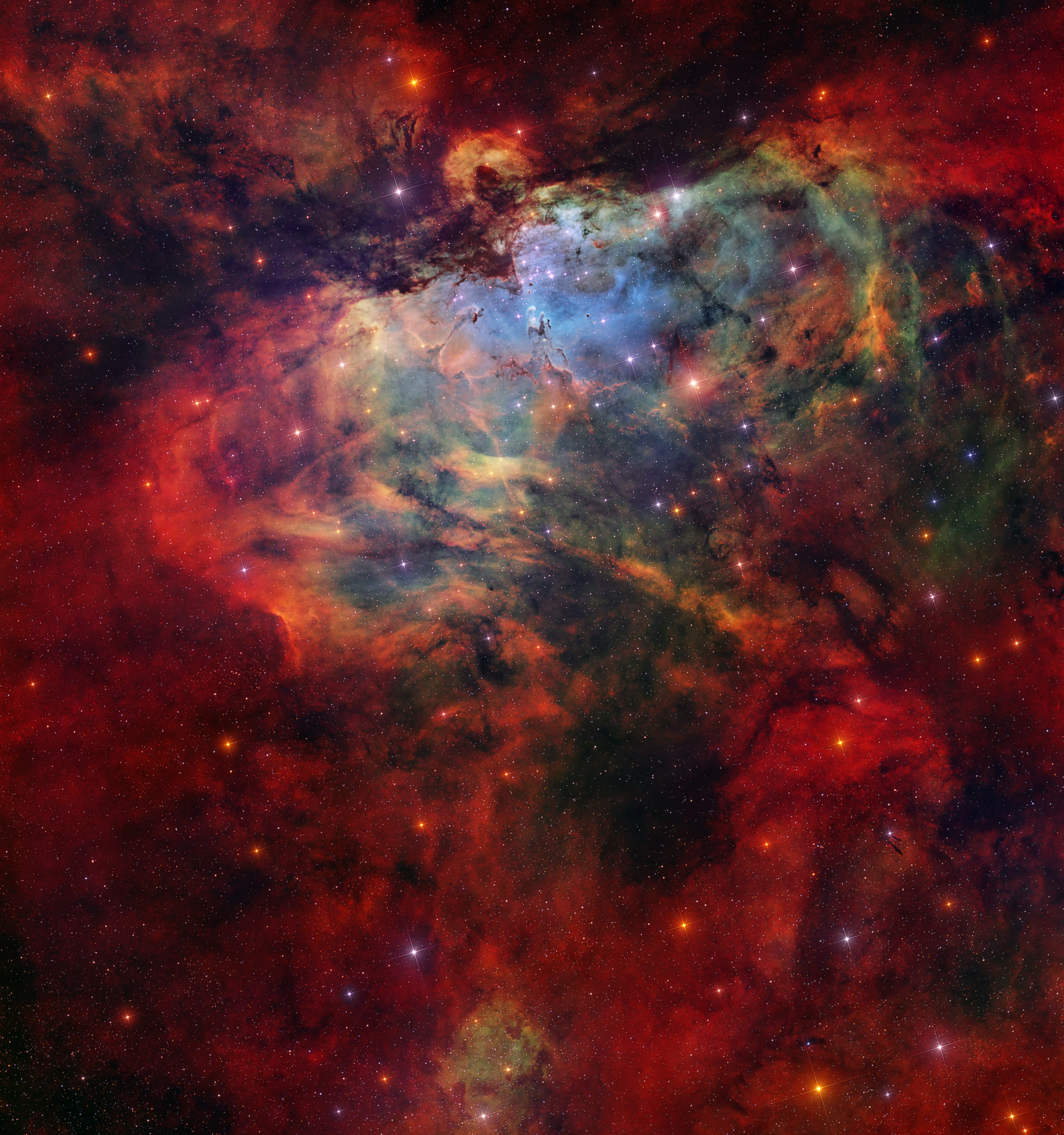 What looks as if it is going to swallow the great Pillars of Creation? The Eagle Nebula (M16) is not a bird, a plane, or Superman. M16 is actually a combination of several celestial objects. NGC 6611 is the young star cluster that appears to peak out beneath the Eagle’s “wings”. The ultraviolet light from these stars ionizes the surrounding gas, creating the emission nebula IC 4703. The Stellar Spire is seen reaching towards the Pillars of Creation from the left. Both are structures of cold gas and dust that are optimal for star formation. Some astronomers previously thought the Pillars of Creation had been evaporated away by a supernova. Because M16 is 6,000 light years away, we would not be able to see the Pillars’ destruction for thousands more years. However, there is no conclusive evidence of the theorized supernova, so the Pillars of Creation will likely continue to create stars for millions of years.