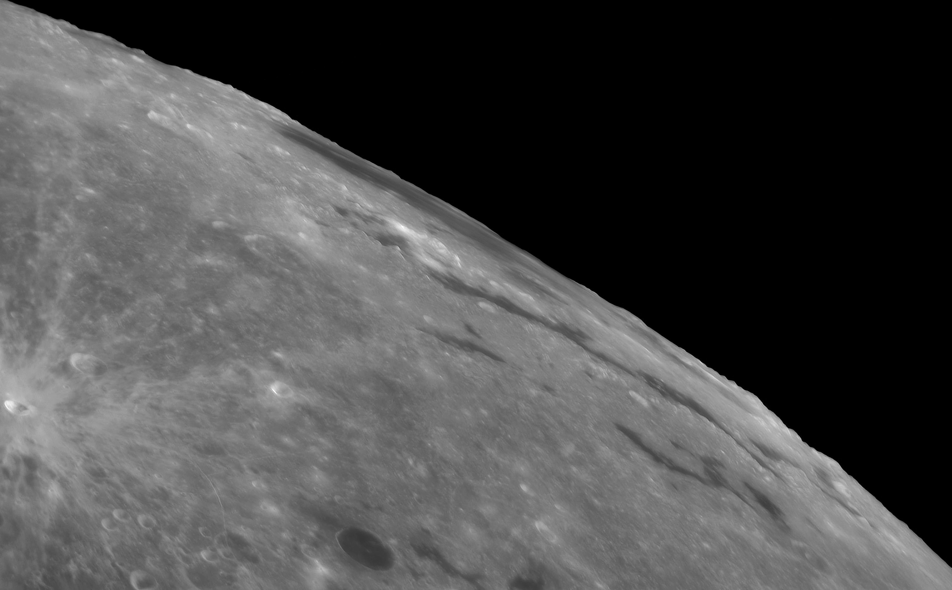 The Mare Orientale, Latin for Eastern Sea, is one of the most striking large scale lunar features. The youngest of the large lunar impact basins it's very difficult to see from an earthbound perspective. Still, captured on July 7 during a period of favorable tilt, or libration of the lunar nearside, the Eastern Sea can be found at the upper right in this sharp telescopic view. In the image, the large lunar mare is extremely foreshortened and stretches along the Moon's western edge. Formed by the impact of an asteroid over 3 billion years ago and nearly 1000 kilometers across, the impact basin's concentric circular features are ripples in the lunar crust. But they are a little easier to spot in more direct images of the region taken from lunar orbit. So why is the Eastern Sea at the Moon's western edge? The Mare Orientale lunar feature was named before 1961. That's when the convention labeling east and west on lunar maps was reversed.