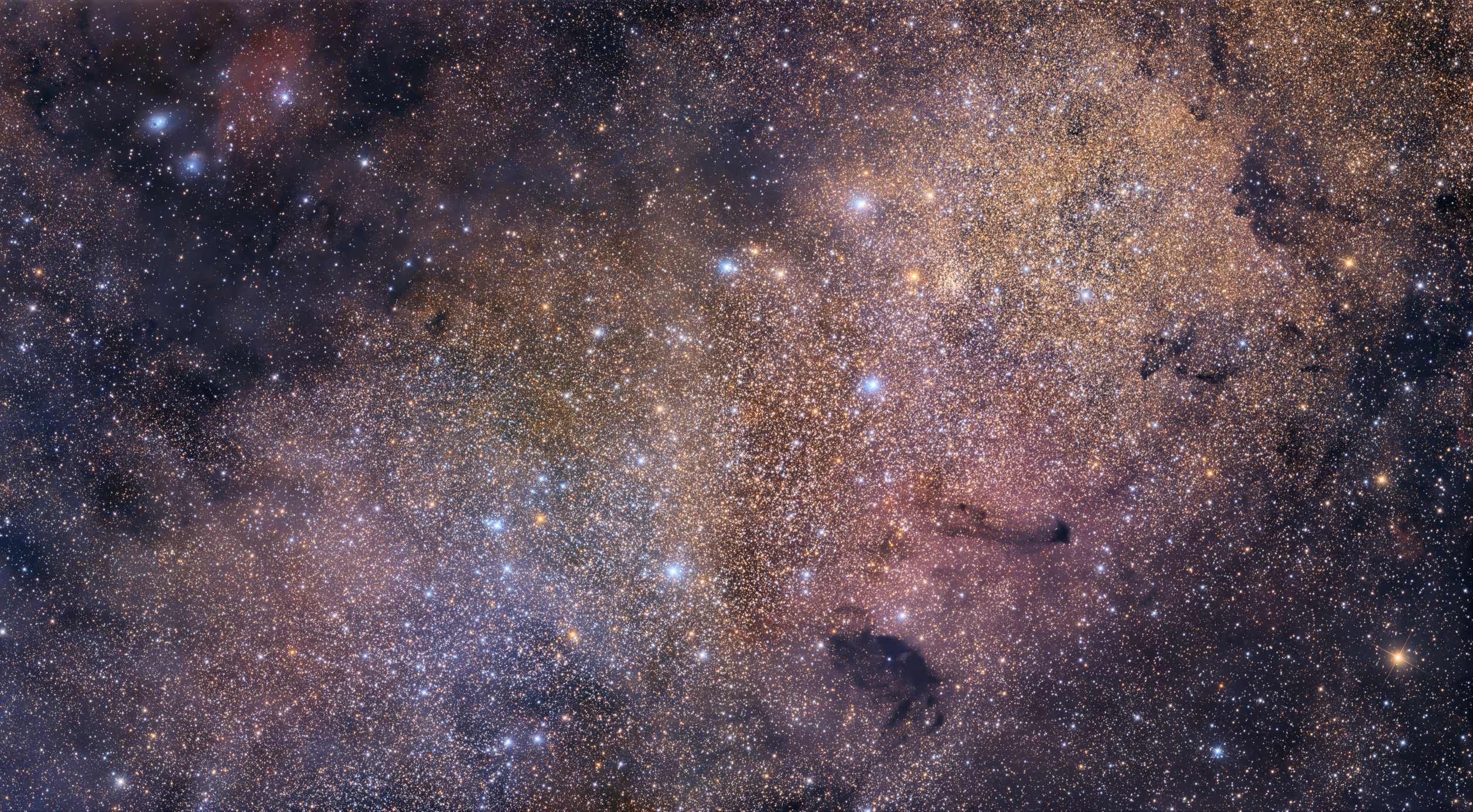 Unlike most entries in Charles Messier's famous catalog of deep sky objects, M24 is not a bright galaxy, star cluster, or nebula. It's a gap in nearby, obscuring interstellar dust clouds that allows a view of the distant stars in the Sagittarius spiral arm of our Milky Way galaxy. Direct your gaze through this gap with binoculars or a small telescope and you are looking through a window over 300 light-years wide at stars some 10,000 light-years or more from Earth. Sometimes called the Small Sagittarius Star Cloud, M24's luminous stars stretch across this gorgeous interstellar scene. Spanning over four full moons on the sky toward the constellation Sagittarius, the telescopic field of view includes dark markings B92 and B93 near the center of M24, along with other clouds of dust and glowing nebulae toward the center of the Milky Way.