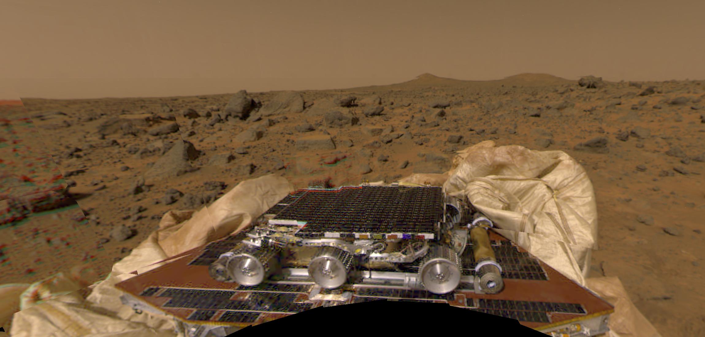 On July 4th, 1997, using its own array of fireworks, a parachute, and a cocoon of airbags, the Mars Pathfinder spacecraft bounced like a giant beach ball at least 15 times before it came to rest on the surface of Mars at 10:07 AM Pacific Daylight Time. After its then novel airbag-assisted landing sequence was completed, Pathfinder transmitted this color mosaic to mission operators on Earth. In the scene from another world, the Mars Sojourner robot rover is visible in the foreground, crouched on top of the unfolded Pathfinder.  About the size of a large house cat, the six-wheeled, solar-powered Sojourner became the first successful Martian rover. Surrounding Pathfinder are deflated airbags and the rock-strewn terrain of the Ares Vallis floodplain. In the distance Martian hills appear against a dusty brownish sky. The Pathfinder lander was subsequently renamed the Carl Sagan Memorial Station.