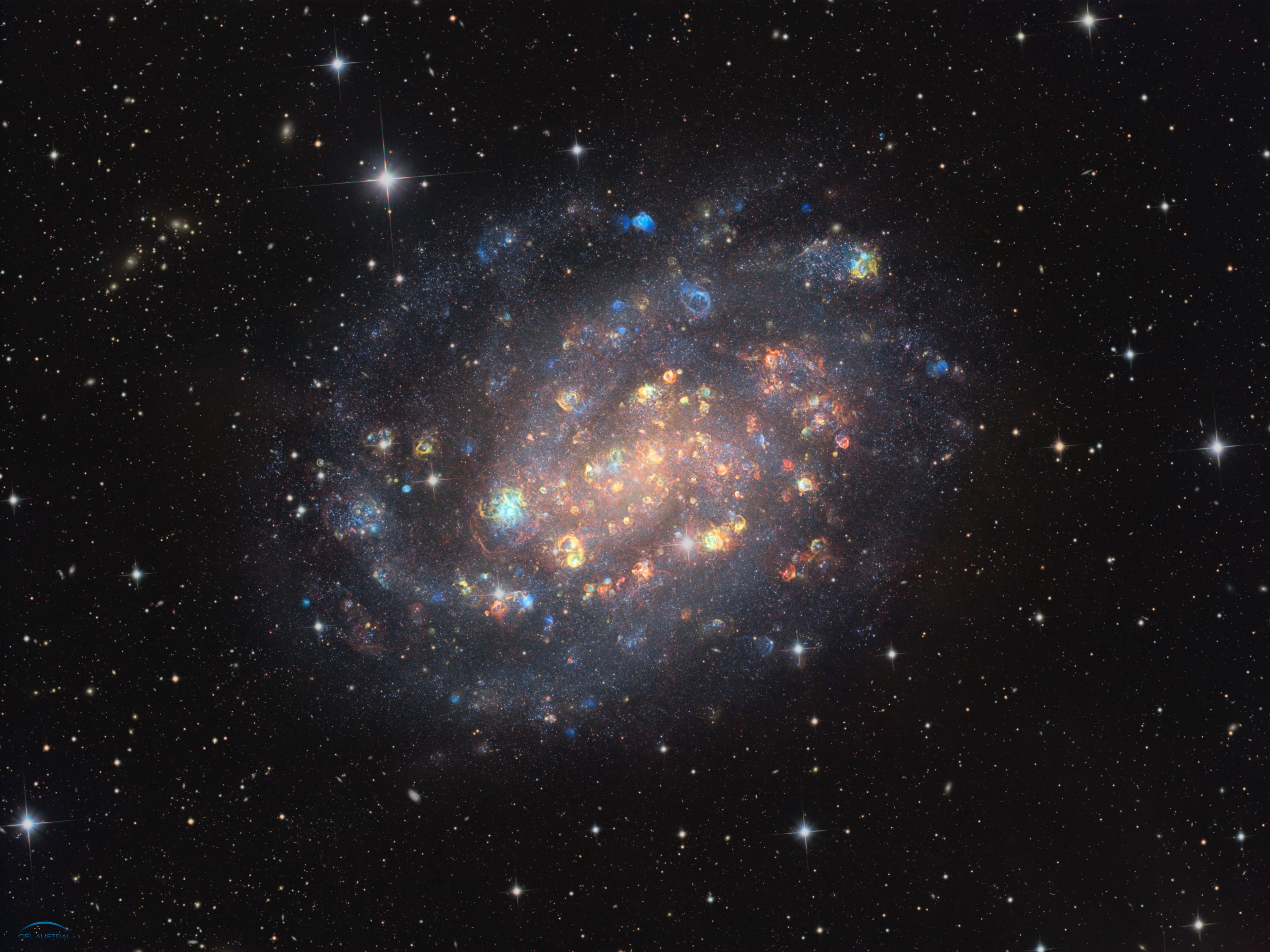 This sparkling, colorful gemstone is a spiral galaxy, NGC 300.   It is one of the closest spiral galaxies to Earth, only about 6 million light-years away.     But does it really look like this?   Here is a more standard portrait of it.   This unusual image combines the light from the stars and dust within the galaxy with the light from ionized clouds of interstellar gas shown in red (Sulphur), green (Hydrogen) and blue (Oxygen).   Combining red and green light in different proportions makes yellow or orange light, most visible in the image.   Light from other ionized gases is also at work in neon signs, fluorescent tubes and street lights.   These massive clouds of ionized gas are typically created by young, massive stars that produce high-energy ultraviolet radiation capable of ionizing the gas.   Massive stars are short-lived, compared with lighter stars like our sun, and explode as supernovas at the end of their lives.   Some of the colorful clouds in the image could be hiding supernova remnants.