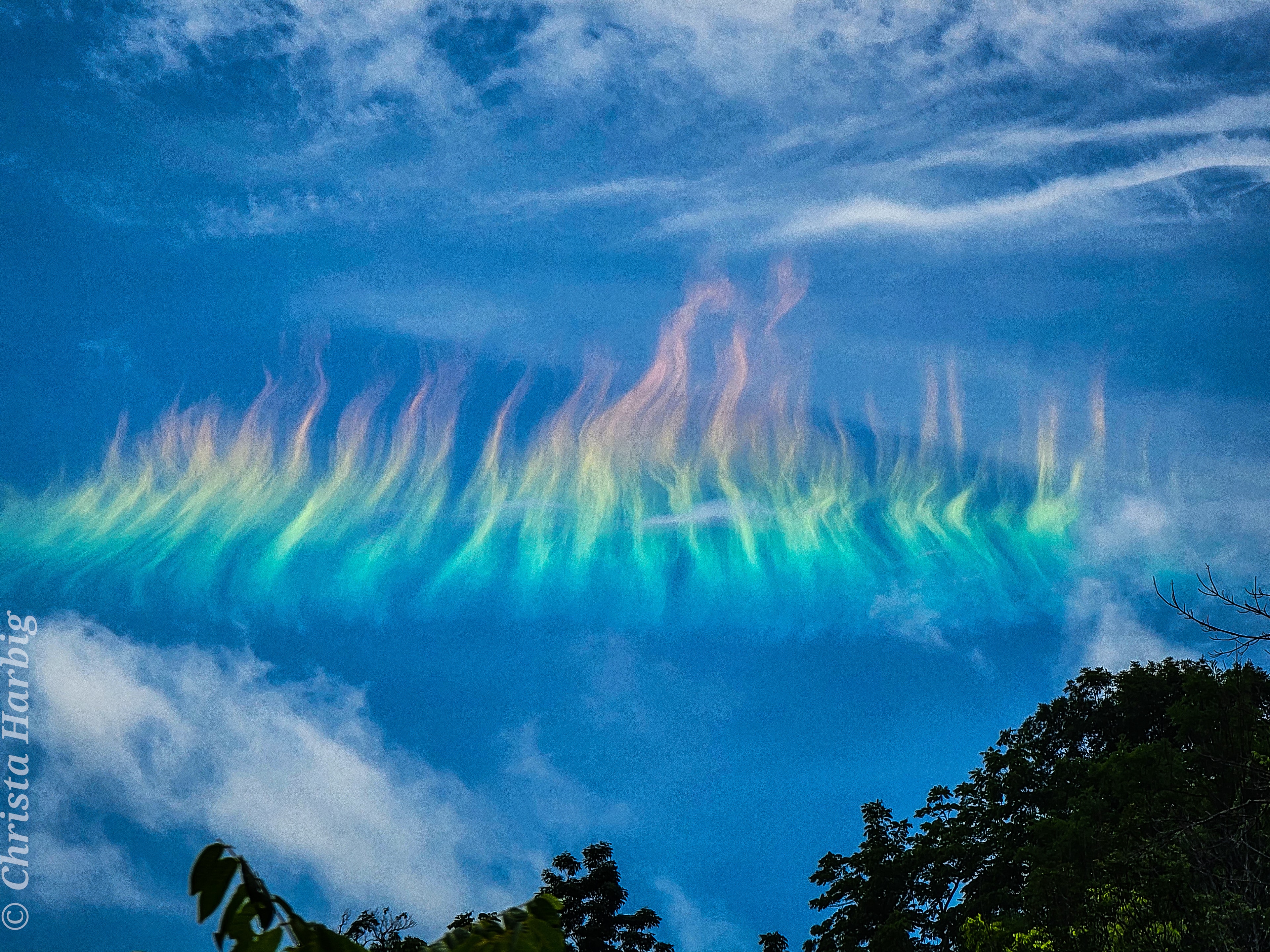 What's happening to this cloud? Ice crystals in a distant cirrus cloud are acting like little floating prisms.  Known informally as a fire rainbow for its flame-like appearance, a circumhorizon arc appears parallel to the horizon. For a circumhorizontal arc to be visible, the Sun must be at least 58 degrees high in a sky where cirrus clouds present below --  in this case cirrus fibratus.  The numerous, flat, hexagonal ice-crystals that compose the cirrus cloud must be aligned horizontally to properly refract sunlight in a collectively similar manner.  Therefore, circumhorizontal arcs are somewhat unusual to see.  The featured fire rainbow was photographed in 2021 near North Fork Mountain in West Virginia, USA.    Sky Surprise: What picture did APOD feature on your birthday? (after 1995)