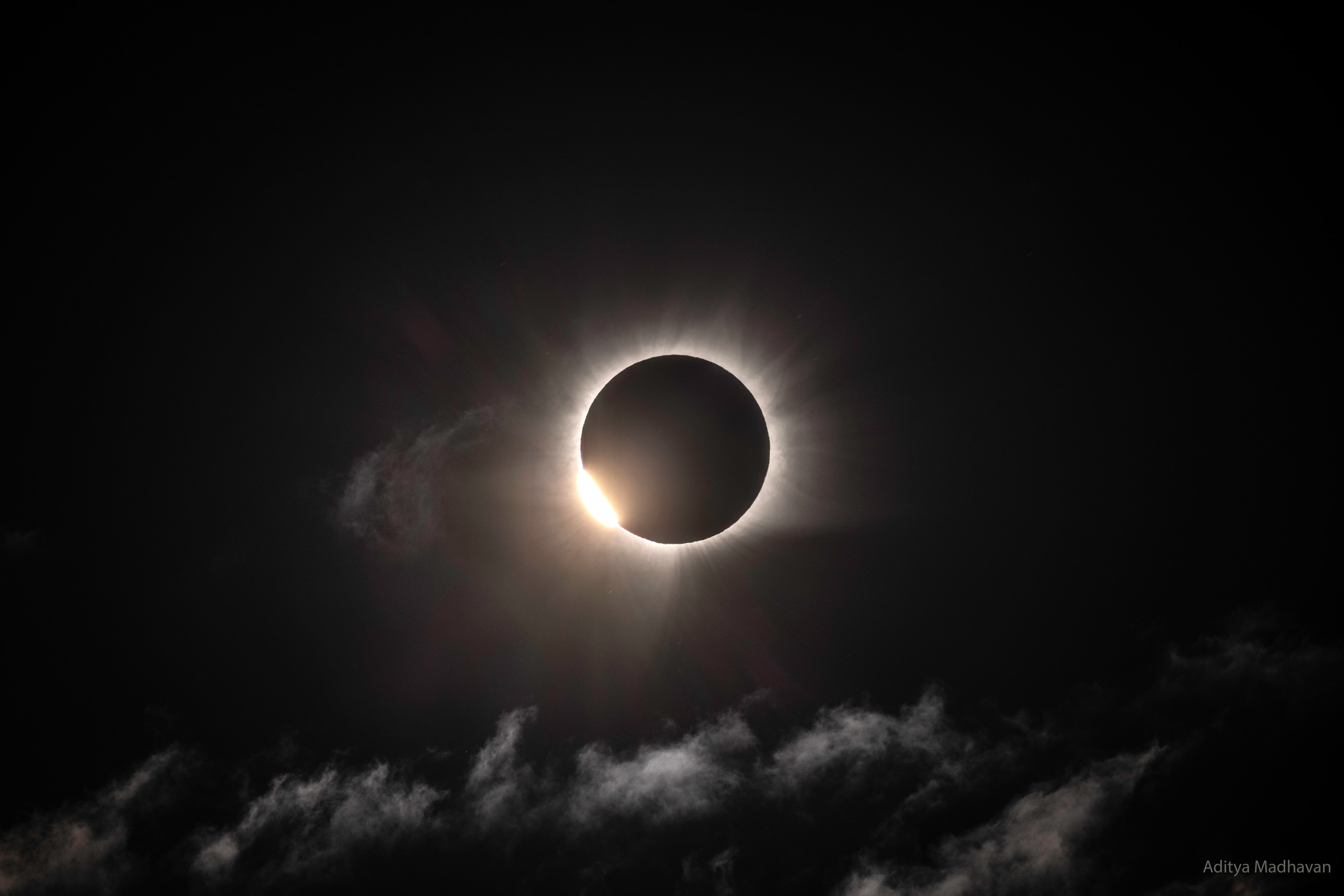 On August 12, the Moon's shadow reached out to touch our fair planet. Beginning in the Arctic Ocean, it swept along a narrow track that led the dark lunar umbra across parts of Greenland, Iceland, the Atlantic, Portugal, and northern Spain. And for a moment, denizens of Earth who found themselves with clear skies under the shadow of the Moon could witness a total solar eclipse. After dodging the weather by sea and making a landing along Rype Fjord on the Greenland east coast (at 71.07055N, 27.71252W), this hard-won snapshot was captured at 17:33:26 UTC. That's near the initial reach of clearing skies along the path of totality, so the image is likely one of the first unobstructed views of the totally eclipsed Sun. Through a break in the clouds, the stunning photo also records one of this eclipse's transient diamond rings and the magnificent solar corona emerging near the moment totality began.  More spectacular eclipse images: Solar Eclipse of 2026 August 12