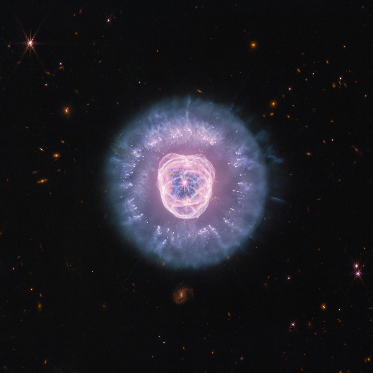 Are we looking at the future of our Sun? The James Webb Space Telescope captured today’s composite image of the Lion’s Head Nebula (NGC 2392) with its NIRCam and MIRI instruments. The Lion’s Head Nebula is the remnant of a Sun-like star. This star was unable to sustain the nuclear fusion in its core needed to remain stable. It began to shed layers of gas and dust into space, forming this planetary nebula. A hot stellar core, called a white dwarf, is left behind within the lion’s nose. Do not boop this nose! Intense radiation from the white dwarf is ionizing the gas as it expands, creating the irregular bubble that makes up the lion’s face. Dust clumps that have survived the white dwarf’s radiation and a cloud of ionized gas make up the lion’s mane. This new and more detailed view of the nebula will help humanity learn more about how the gas and dust interact with each other and the white dwarf radiation.