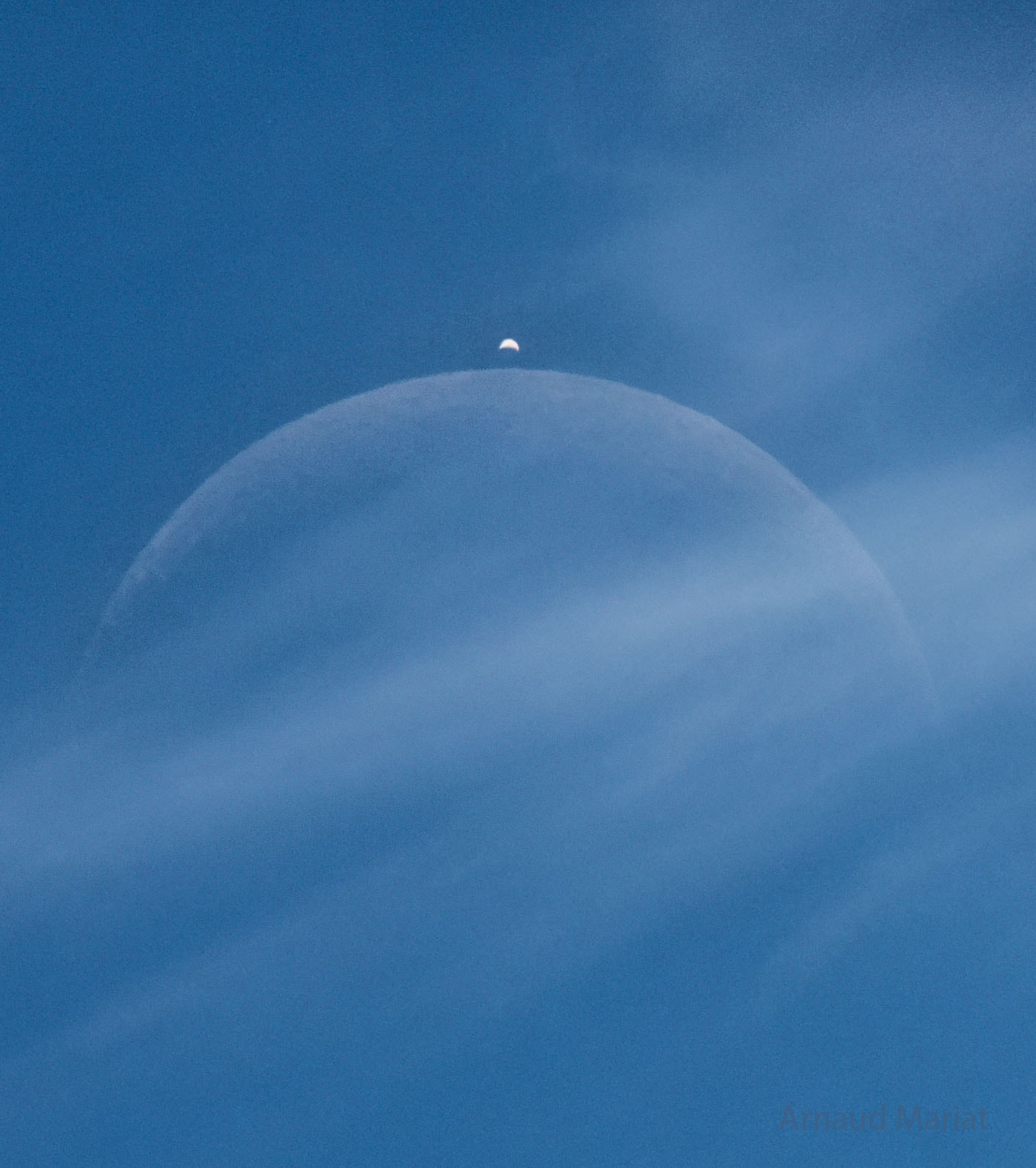 There was something behind the clouds.  Upon close inspection, it was the Moon, which was hard to see yesterday around noon above the small village of Cessy, France.  But soon, it was not only the Moon. As expected, a bright dot suddenly appeared from behind the Moon -- the planet Venus far in the distance.  Captured in the single featured exposure, both appeared to show a crescent phase.  The Moon's crescent was quite slight -- with only about 10 percent of its face illuminated by the Sun. In contrast, Venus's crescent was more full -- showing about 25 percent illumination. Venus appeared brighter because it is nearer the Sun and because its clouds are more reflective than the dark lunar surface. An occultation of Venus by the Moon is visible to only about 10 percent of the Earth, but in yesterday's event even most of that was experiencing daytime.   APOD's main NASA site is moving: From apod.nasa.gov to science.nasa.gov/apod