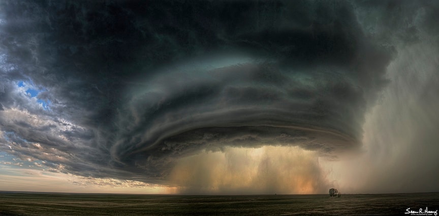 Is that a spaceship or a cloud? Although it may seem like an alien mothership, it's actually a impressive thunderstorm cloud called a supercell. Such colossal storm systems center on mesocyclones -- rotating updrafts that can span several kilometers and deliver torrential rain and high winds including tornadoes. Jagged sculptured clouds adorn the supercell's edge, while wind swept dust and rain dominate the center. A tree waits patiently in the foreground. The above supercell cloud was photographed in 2010 July west of Glasgow, Montana, USA, caused minor damage, and lasted several hours before moving on. Today: Southern Hemisphere Solar Eclipse