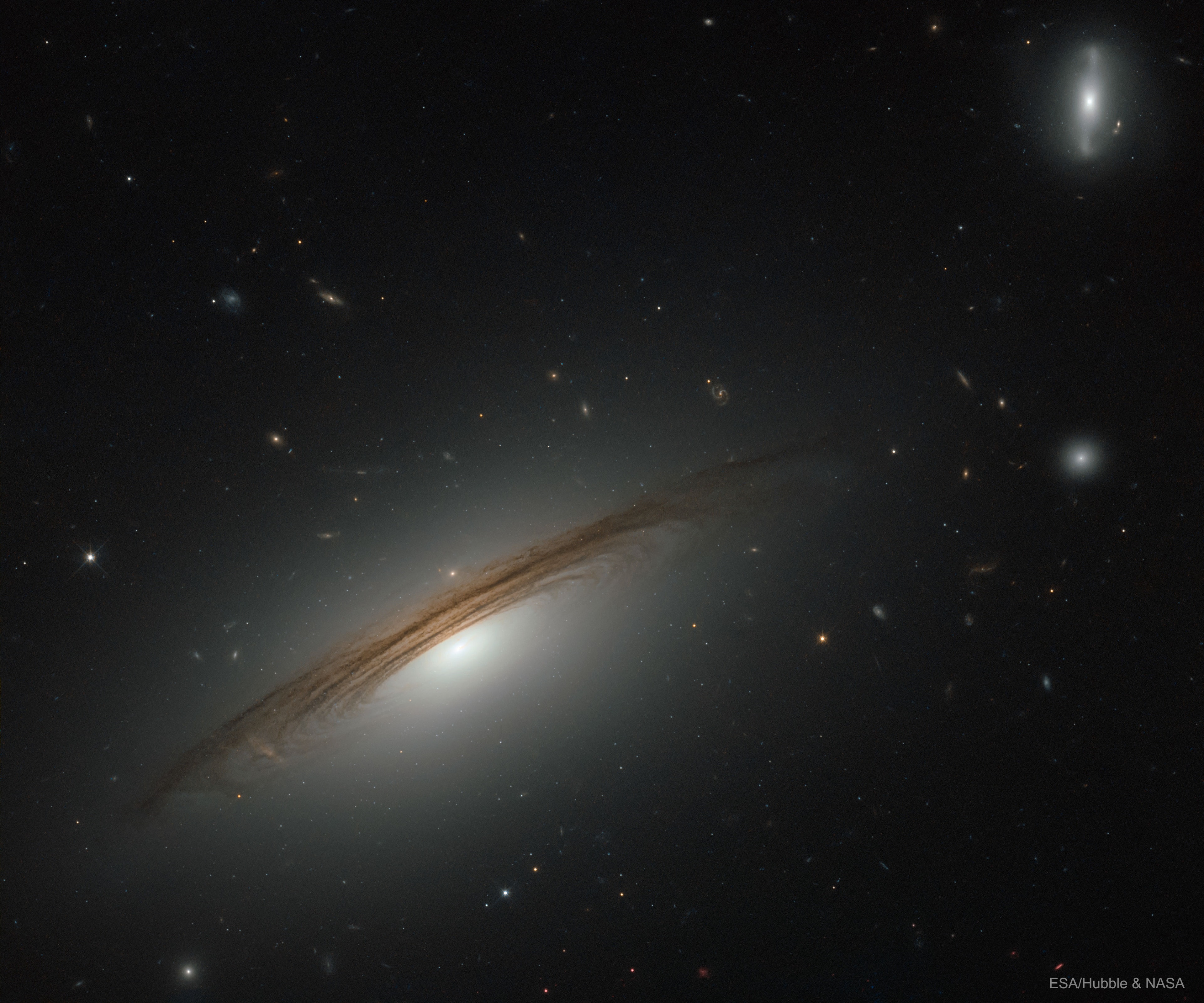 Why does this galaxy spin so fast? To start, even identifying which type of galaxy UGC 12591 is difficult -- it has dark dust lanes like a spiral galaxy but a large diffuse bulge of stars like a lenticular. Surprisingly observations show that UGC 12591 spins at about 480 km/sec, almost twice as fast as our Milky Way, and the fastest rotation rate yet measured. The mass needed to hold together a galaxy spinning this fast is several times the mass of our Milky Way Galaxy. Progenitor scenarios for UGC 12591 include slow growth by accreting ambient matter, or rapid growth through a recent galaxy collision or collisions -- future observations may tell. The light we see today from UGC 12591 left about 400 million years ago, when trees were first developing on Earth. Open Science: Browse 1,400+ codes in the Astrophysics Source Code Library