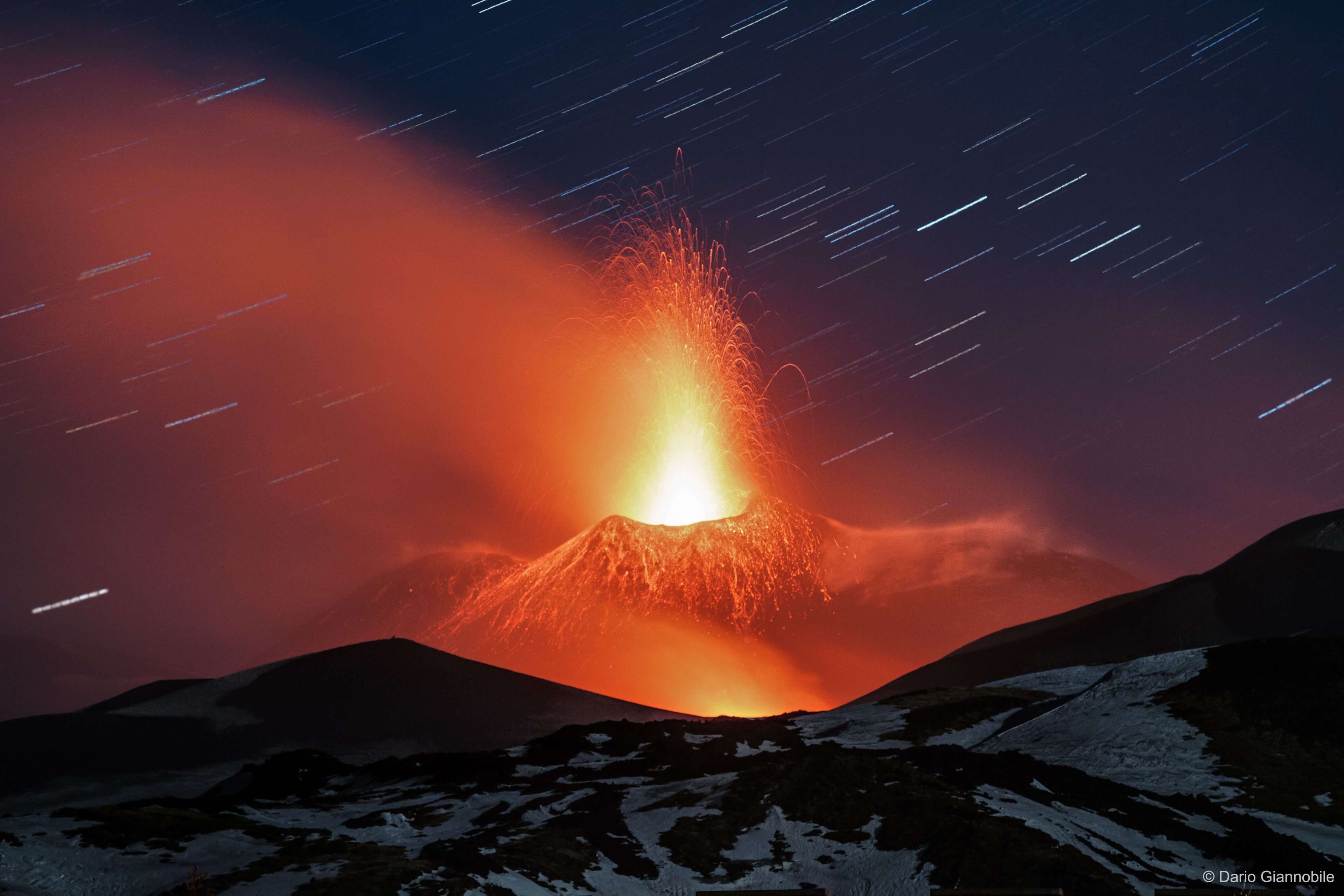 Mt. Etna has been erupting for hundreds of thousands of years. Located in Sicily, Italy, the volcano produces lava fountains over one kilometer high. Mt. Etna is not only one of the most active volcanoes on Earth, it is one of the largest, measuring over 50 kilometers at its base and rising nearly 3 kilometers high. Pictured in mid-March, a spectacular lava plume erupts upwards, dangerous molten volcanic bombs fly off to the sides, while hot lava flows down the volcano's exterior. The Earth's rotation is discernable on this carefully time, moon-lit, long duration image as star trails. Follow APOD on: Facebook, Google Plus, Instagram, or Twitter