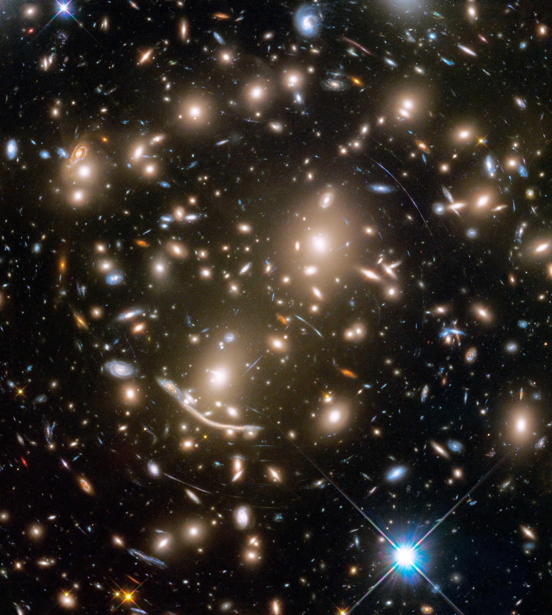 Some 4 billion light-years away, massive galaxy cluster Abell 370 only appears to be dominated by two giant elliptical galaxies and infested with faint arcs in this sharp Hubble Space Telescope snapshot. The fainter, scattered bluish arcs along with the dramatic dragon arc below and left of center are images of galaxies that lie far beyond Abell 370. About twice as distant, their otherwise undetected light is magnified and distorted by the cluster's enormous gravitational mass, dominated by unseen dark matter. Providing a tantalizing glimpse of galaxies in the early universe, the effect is known as gravitational lensing. A consequence of warped spacetime it was first predicted by Einstein a century ago. Far beyond the spiky foreground Milky Way star at lower right, Abell 370 is seen toward the constellation Cetus, the Sea Monster. It is the last of six galaxy clusters imaged in the recently concluded Frontier Fields project.