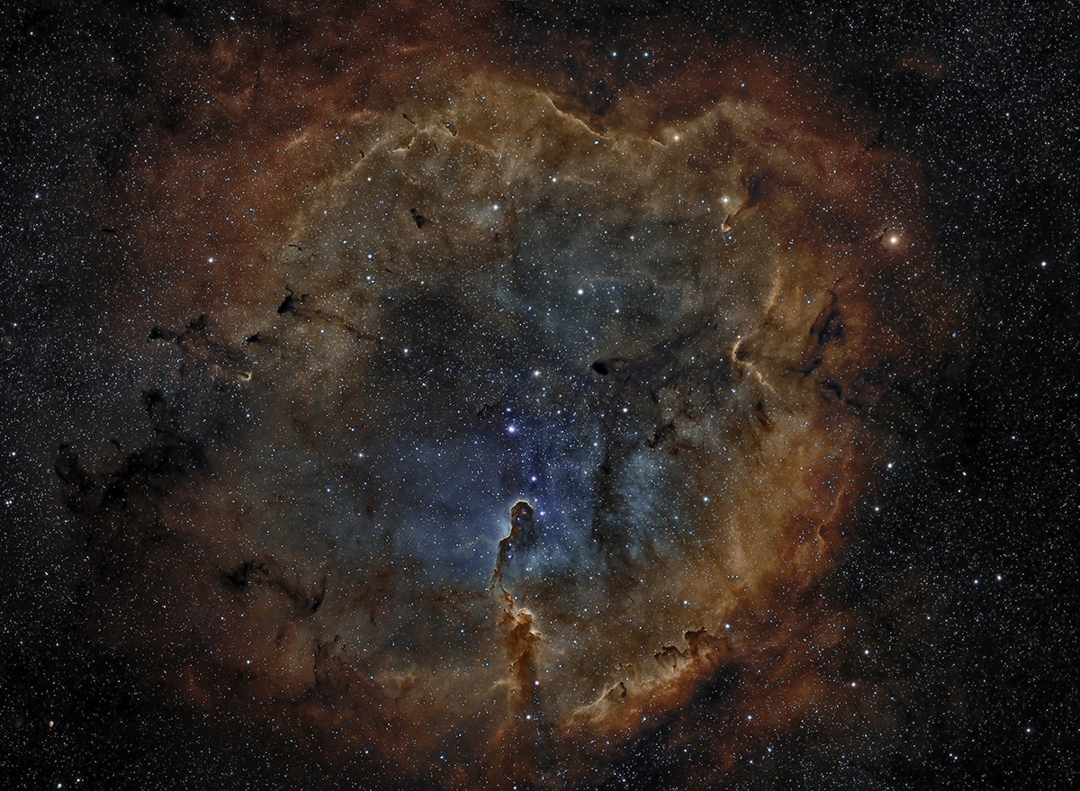 Stunning emission nebula IC 1396 mixes glowing cosmic gas and dark dust clouds in the high and far off constellation of Cepheus. Energized by the bright central star seen here, this star forming region sprawls across hundreds of light-years, spanning over three degrees on the sky while nearly 3,000 light-years from planet Earth. Among the intriguing dark shapes within IC 1396, the winding Elephant's Trunk nebula lies just below center. Stars could still be forming inside the dark shapes by gravitational collapse. But as the denser clouds are eroded away by powerful stellar winds and radiation, any forming stars will ultimately be cutoff from the reservoir of star stuff. The gorgeous color view is a composition of image data from narrowband filters, mapping emission from the nebula's atomic oxygen, hydrogen, and sulfur into blue, green, and red hues.