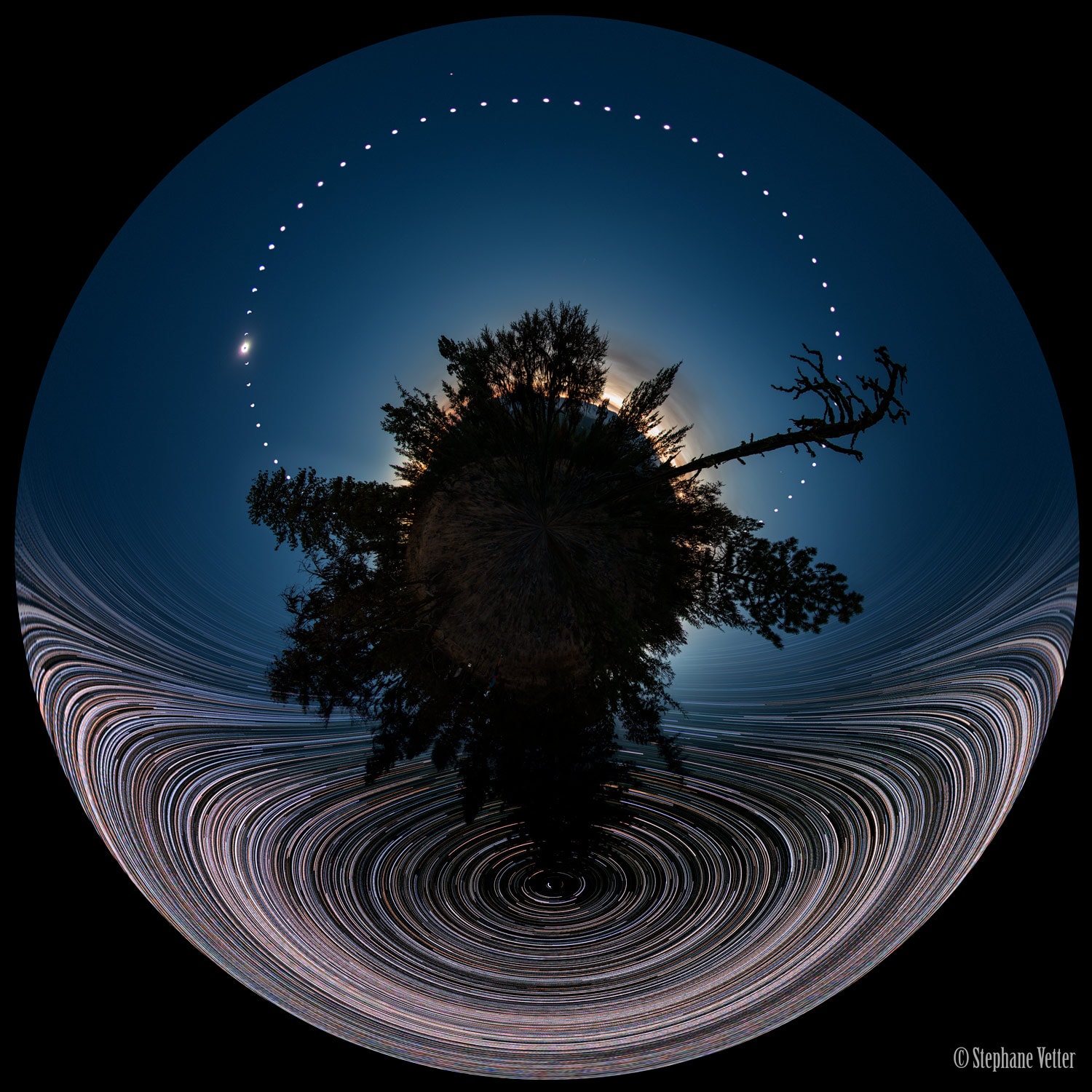 What was happening in the sky during last week's total solar eclipse? This featured little-planet, all-sky, double time-lapse, digitally-fused composite captured celestial action during both night and day from a single location. In this 360x180 panorama, north and south are at the image bottom and top, while east and west are at the left and right edges, respectively. During four hours the night before the eclipse, star trails were captured circling the north celestial pole (bottom) as the Earth spun. During the day of the total eclipse, the Sun was captured every fifteen minutes from sunrise to sunset (top), sometimes in partial eclipse. All of these images were then digitally merged onto a single image taken exactly during the total solar eclipse. Then, the Sun's bright corona could be seen flaring around the dark new Moon (upper left), while Venus simultaneously became easily visible (top). The tree in the middle, below the camera, is a Douglas fir. The images were taken with care and planning at Magone Lake in Oregon, USA. Total Eclipse 2017: More memorable images -- please "Like" your favorites.