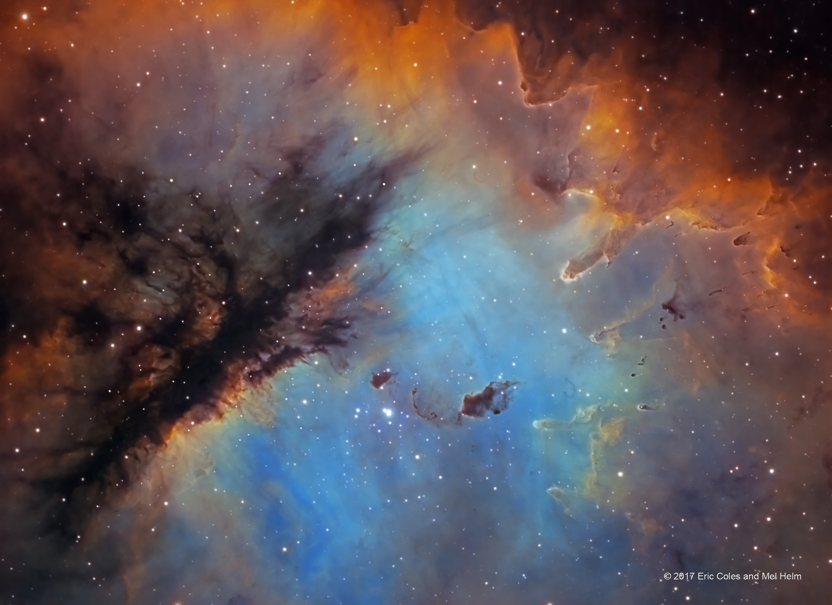Look through the cosmic cloud cataloged as NGC 281 and you might miss the stars of open cluster IC 1590. Still, formed within the nebula that cluster's young, massive stars ultimately power the pervasive nebular glow. The eye-catching shapes looming in this portrait of NGC 281 are sculpted columns and dense dust globules seen in silhouette, eroded by intense, energetic winds and radiation from the hot cluster stars. If they survive long enough, the dusty structures could also be sites of future star formation. Playfully called the Pacman Nebula because of its overall shape, NGC 281 is about 10,000 light-years away in the constellation Cassiopeia. This sharp composite image was made through narrow-band filters, combining emission from the nebula's hydrogen, sulfur, and oxygen atoms in green, red, and blue hues. It spans over 80 light-years at the estimated distance of NGC 281.