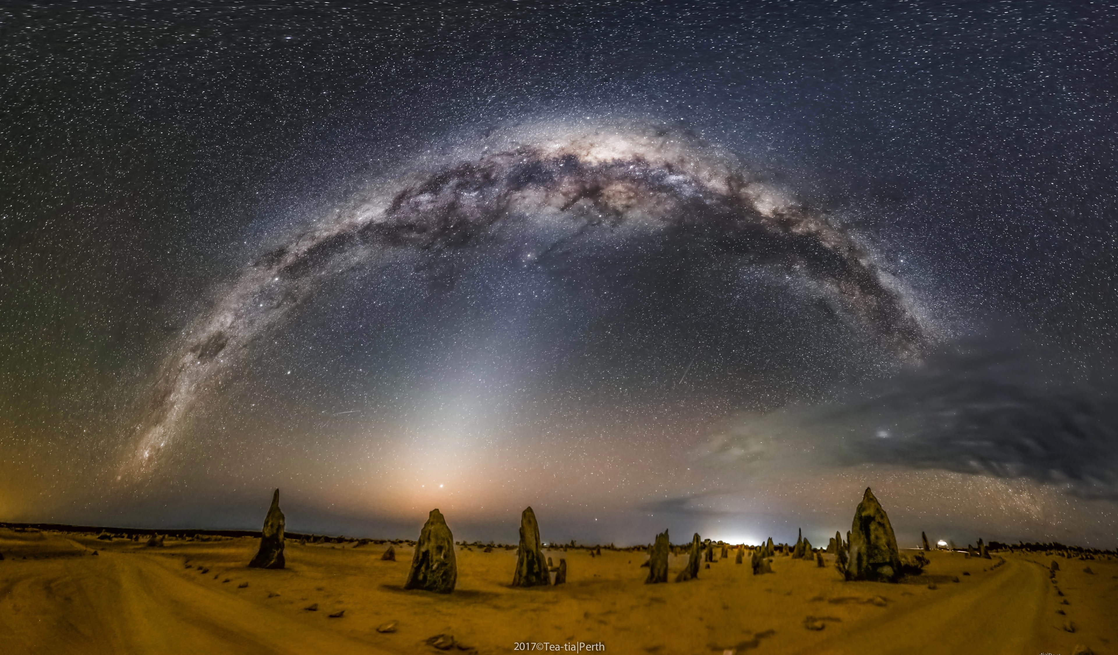 What strange world is this? Earth. In the foreground of the featured image are the Pinnacles, unusual rock spires in Nambung National Park in Western Australia. Made of ancient sea shells (limestone), how these human-sized picturesque spires formed remains a topic of research. The panorama was taken last month. A ray of zodiacal light, sunlight reflected by dust grains orbiting between the planets in the Solar System, rises from the horizon near the image center. Arching across the top is the central band of our Milky Way Galaxy. The planets Jupiter and Saturn, as well as several famous stars are also visible in the background night sky. Free Download: The 2018 APOD Calendar