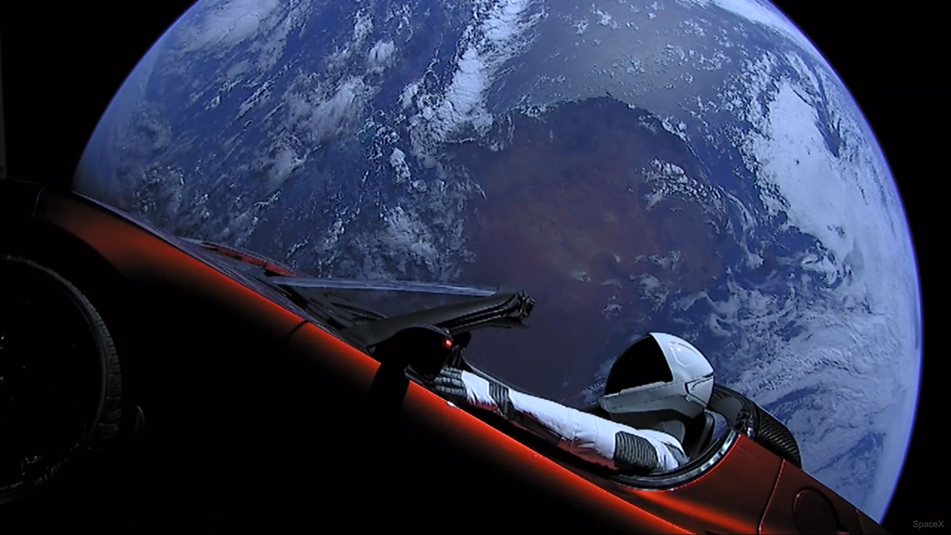 Last week, a car orbited the Earth. The car, created by humans and robots on the Earth, was launched by the SpaceX Company to demonstrate the ability of its Falcon Heavy Rocket to place spacecraft out in the Solar System. Purposely fashioned to be whimsical, the iconic car was thought a better demonstration object than concrete blocks. A mannequin clad in a spacesuit -- dubbed the Starman -- sits in the driver's seat. The featured image is a frame from a video taken by one of three cameras mounted on the car. These cameras, connected to the car's battery, are now out of power. The car, attached to a second stage booster, soon left Earth orbit and will orbit the Sun between Earth and the asteroid belt indefinitely -- perhaps until billions of years from now when our Sun expands into a Red Giant. If ever recovered, what's left of the car may become a unique window into technologies developed on Earth in the 20th and early 21st centuries.