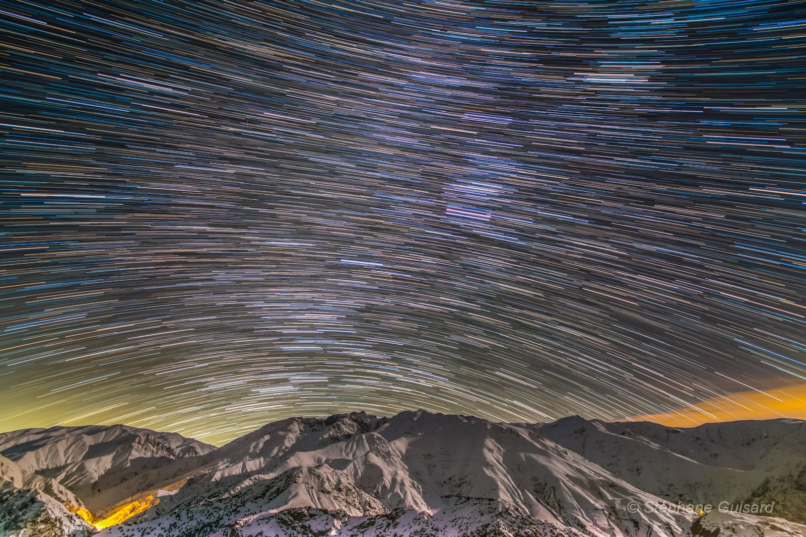 Colourful star trails arc through the night in this wide-angle mountain and skyscape. From a rotating planet, the digitally added consecutive exposures were made with a camera fixed to a tripod and looking south, over northern Iran's Alborz Mountain range. The stars trace concentric arcs around the planet's south celestial pole, below the scene's rugged horizon. Combined, the many short exposures also bring out the pretty star colours. Bluish trails are from stars hotter than our Sun, while yellowish trails are from cooler stars. Near the center, the remarkably pinkish trail was traced by the star-forming Orion Nebula.