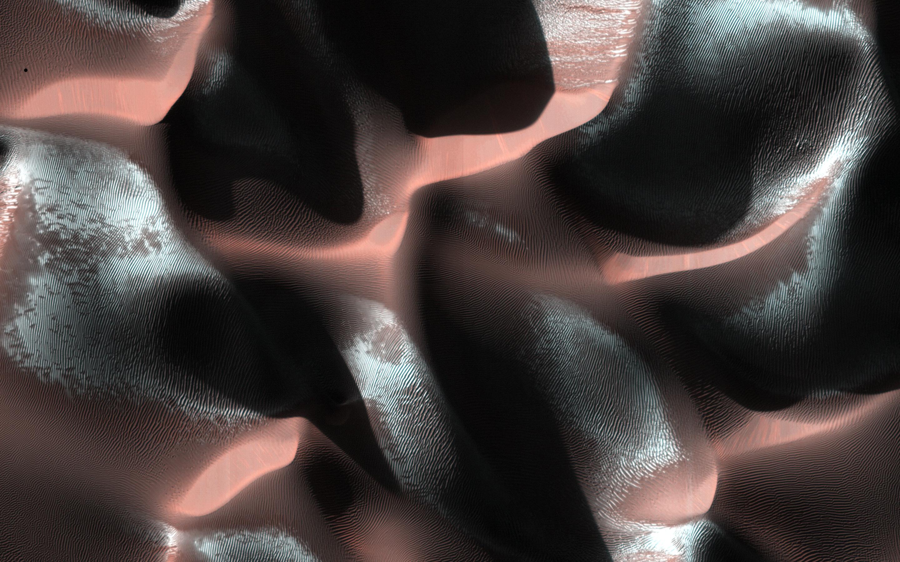 Deep shadows create dramatic contrasts between light and dark in this high-resolution close-up of the martian surface. Recorded on January 24, 2014 by the HiRISE camera onboard the Mars Reconnaissance Orbiter, the scene spans about 1.5 kilometers. From 250 kilometers above the Red Planet the camera is looking down at a sand dune field in a southern highlands crater. Captured when the Sun was about 5 degrees above the local horizon, only the dune crests were caught in full sunlight. A long, cold winter is coming to the southern hemisphere and bright ridges of seasonal frost line the martian dunes.