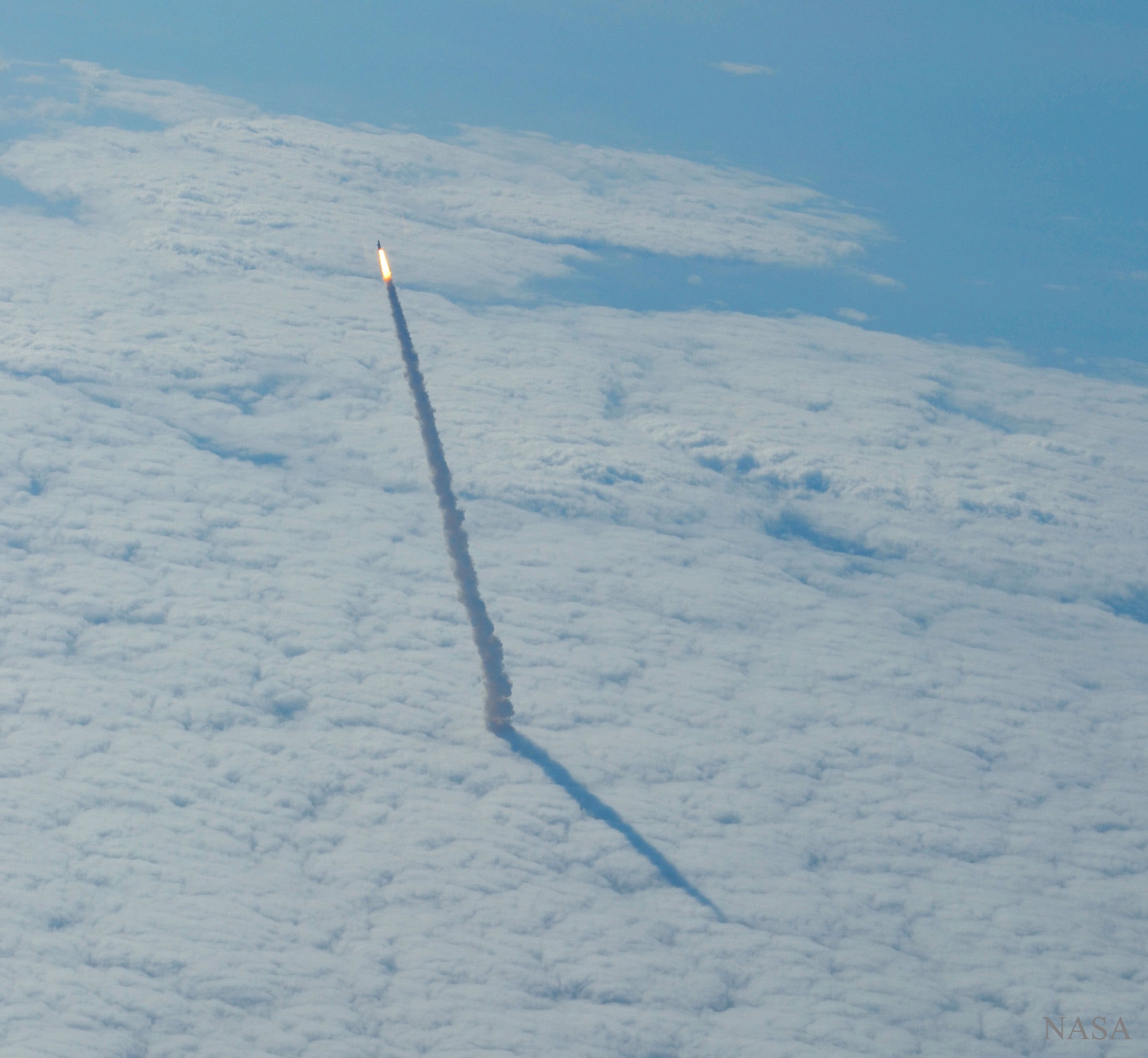 What's that rising from the clouds? The space shuttle. Sometimes, if you look out the window of an airplane at just the right time and place, you see something unusual -- in this case a space shuttle launching to orbit. The featured image of Endeavour's final launch in 2011 May was captured from a NASA shuttle training aircraft. Taken well above the clouds, the image can be matched with similar images of the same shuttle plume taken below the clouds. Hot glowing gasses expelled by the engines are visible near the rising shuttle, as well as a long smoke plume. A shadow of the plume appears on the cloud deck, indicating the direction of the Sun. The US Space Shuttle program concluded in 2011, and Endeavour can now be visited at the California Science Center. Planned for tomorrow, however, is a different launch -- that of the Transiting Exoplanet Survey Satellite (TESS) aboard a SpaceX Falcon 9 rocket.