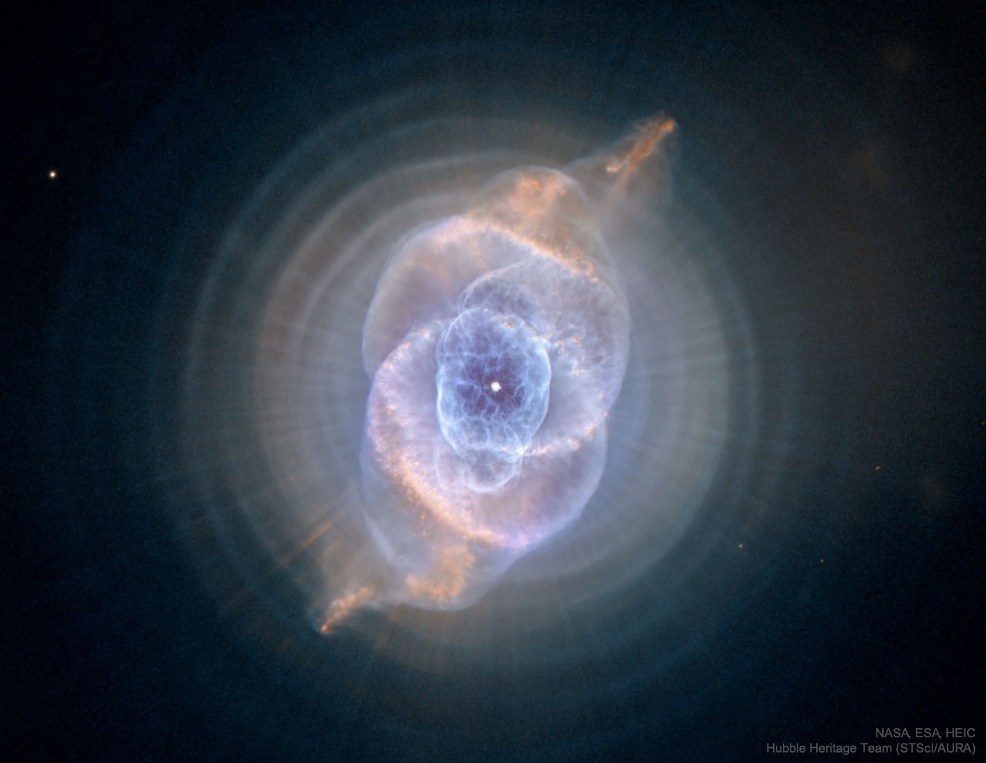 To some, it may look like a cat's eye. The alluring Cat's Eye nebula, however, lies three thousand light-years from Earth across interstellar space. A classic planetary nebula, the Cat's Eye (NGC 6543) represents a final, brief yet glorious phase in the life of a sun-like star. This nebula's dying central star may have produced the simple, outer pattern of dusty concentric shells by shrugging off outer layers in a series of regular convulsions. But the formation of the beautiful, more complex inner structures is not well understood. Seen so clearly in this digitally sharpened Hubble Space Telescope image, the truly cosmic eye is over half a light-year across. Of course, gazing into this Cat's Eye, astronomers may well be seeing the fate of our sun, destined to enter its own planetary nebula phase of evolution ... in about 5 billion years.