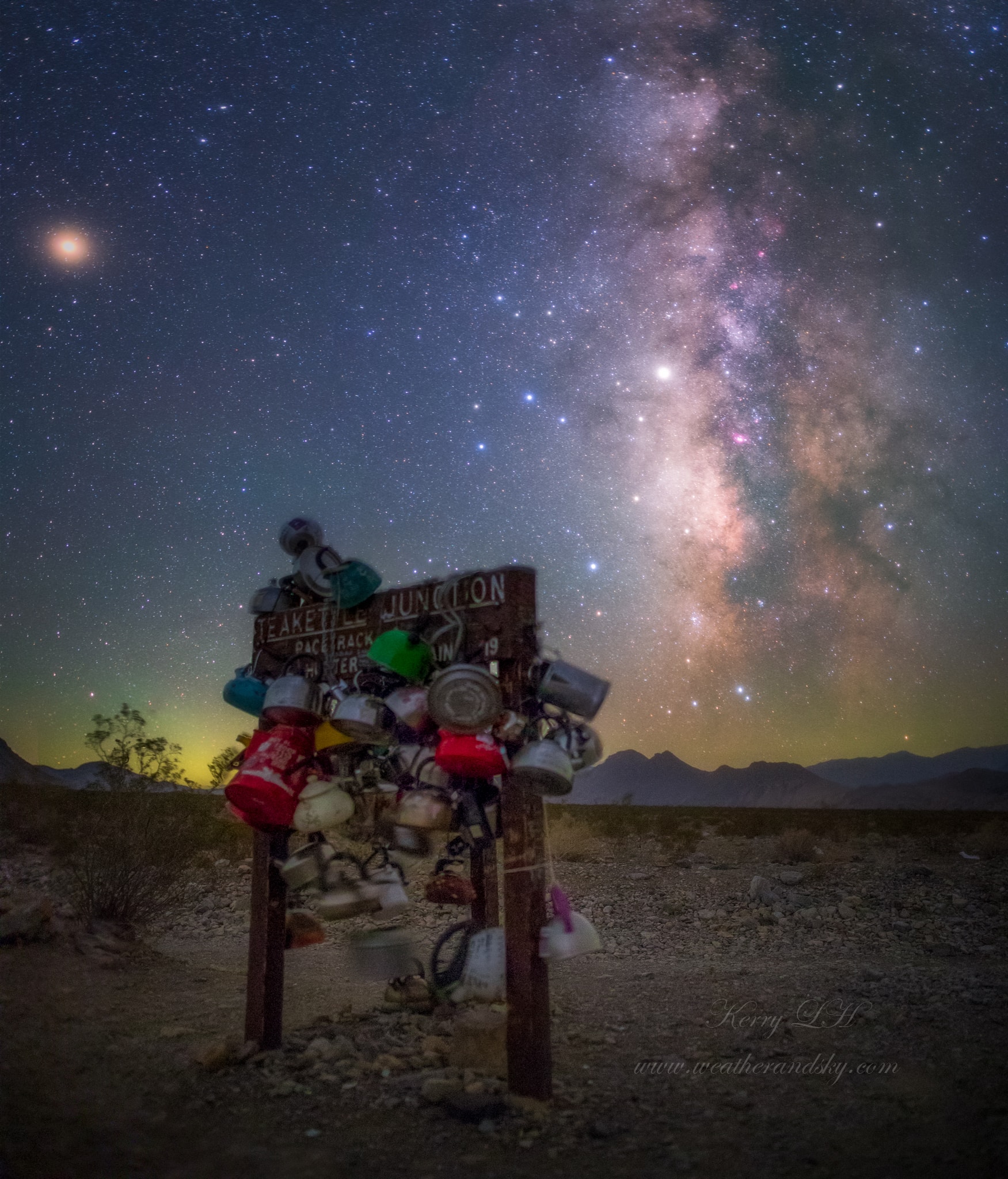 The recognizable stars of the Teapot asterism in the constellation Sagittarius posed with the Milky Way over Death Valley, planet Earth on this quiet, dark night. The surreal scene was appropriately captured from Teakettle Junction, marked by the wooden sign adorned with terrestrial teapots and kettles on the rugged road to Racetrack Playa. Shining against the luminous starlight of the central Milky Way is bright planet Saturn, just above the star at the celestial teapot's peak. But the brightest celestial beacon, high above the southern horizon, is an orange tinted Mars at upper left in the frame.
