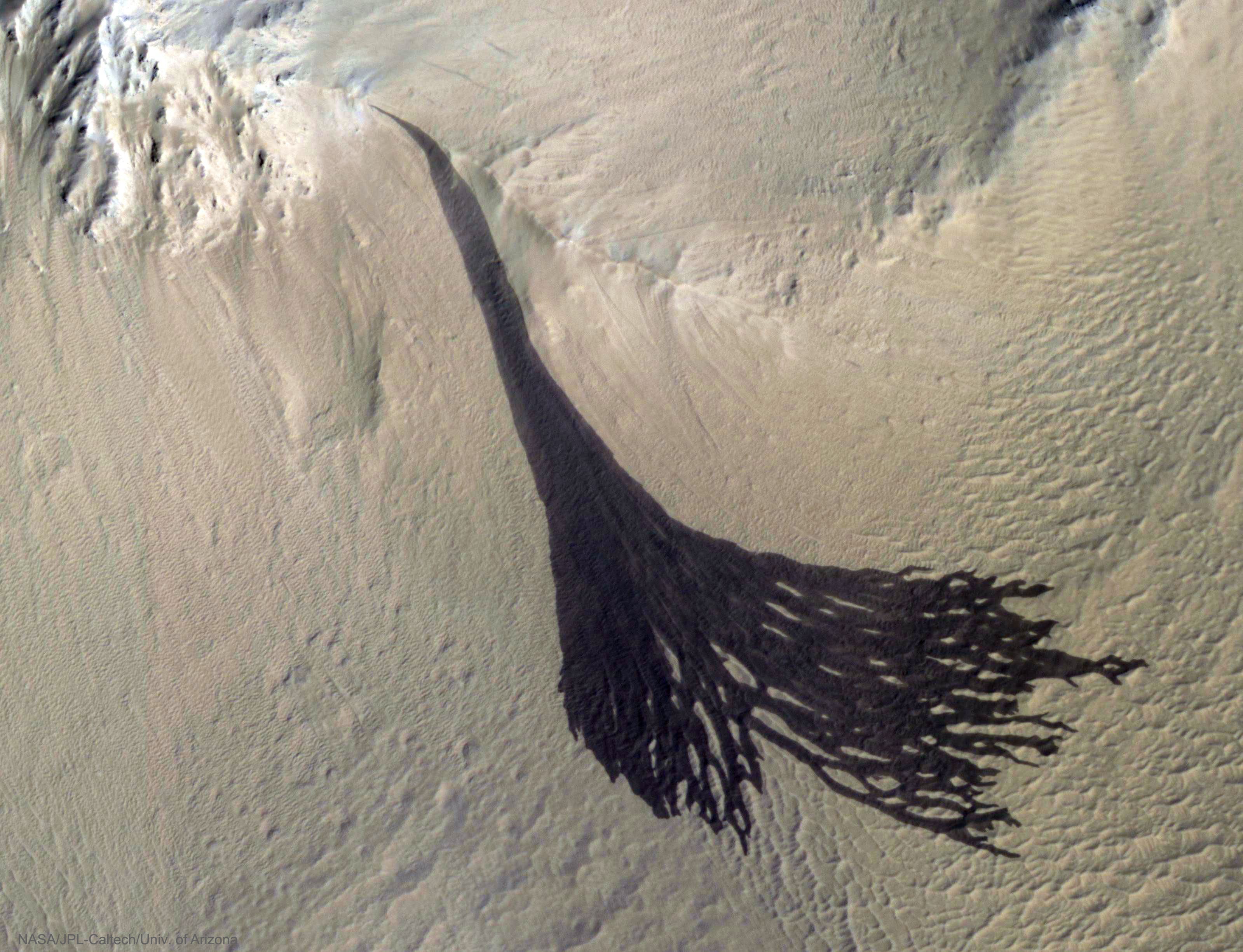 What is creating these dark streaks on Mars? No one is sure. Candidates include dust avalanches, evaporating dry ice sleds, and liquid water flows. What is clear is that the streaks occur through light surface dust and expose a deeper dark layer. Similar streaks have been photographed on Mars for years and are one of the few surface features that change their appearance seasonally. Particularly interesting here is that larger streaks split into smaller streaks further down the slope. The featured image was taken by the HiRISE camera on board the Mars-orbiting Mars Reconnaissance Orbiter (MRO) several months ago. Currently, a global dust storm is encompassing much of Mars.