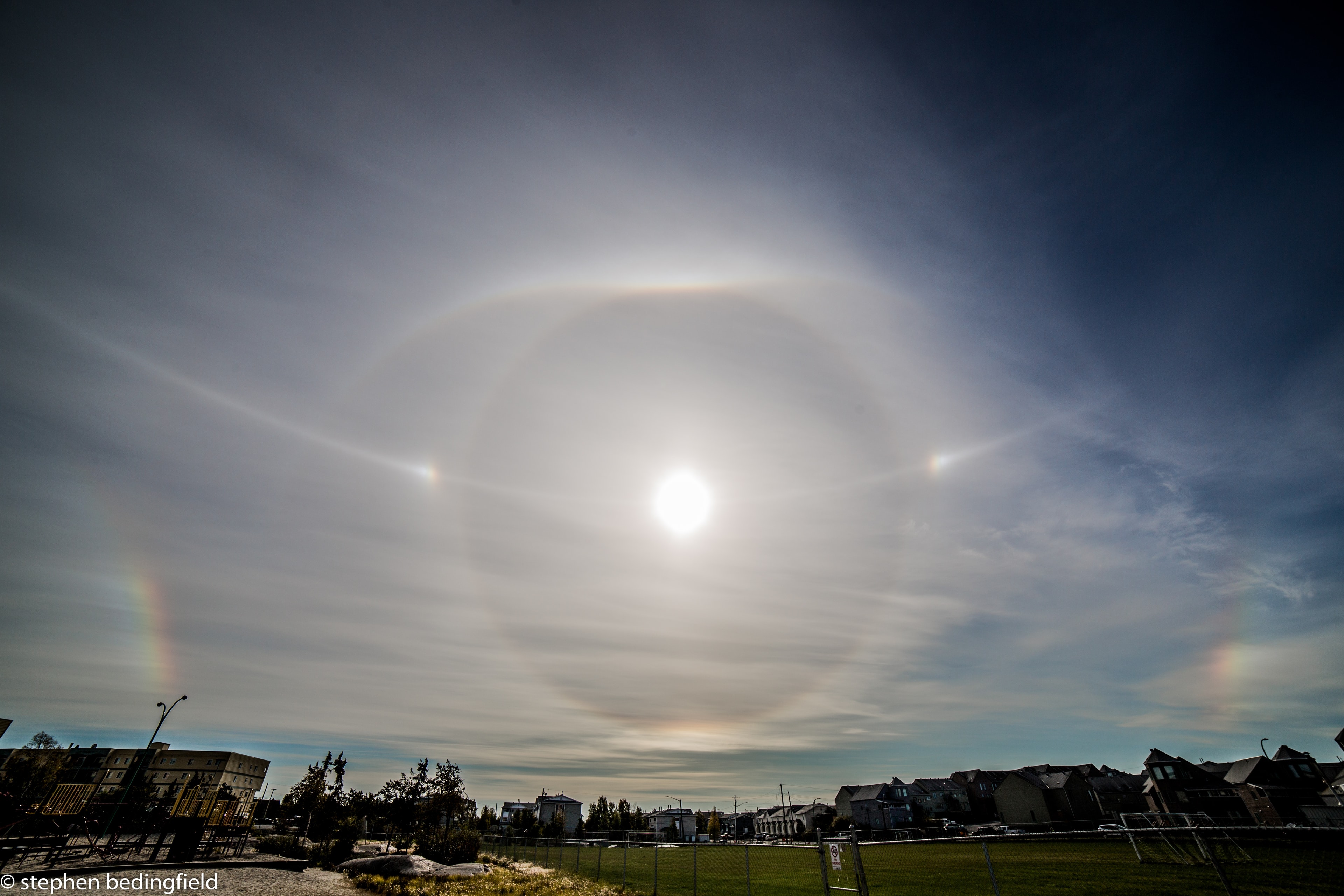 You've probably seen a circle around the Sun before. More common than rainbows, ice halos, like a 22 degree circular halo for example, can be easy to spot, especially if you can shade your eyes from direct sunlight. Still it's rare to see such a diverse range of ice halos, including sundogs, tangent, infralateral, and Parry arcs, all found in this snapshot from planet Earth. The picture was quickly taken in the late morning of September 4 from Yellowknife, Northwest Territories, Canada. The beautiful patterns are generated as sunlight (or moonlight) is reflected and refracted in six-sided water ice crystals in Earth's atmosphere. Of course, atmospheric ice halos in the skies of other worlds are likely to be different.