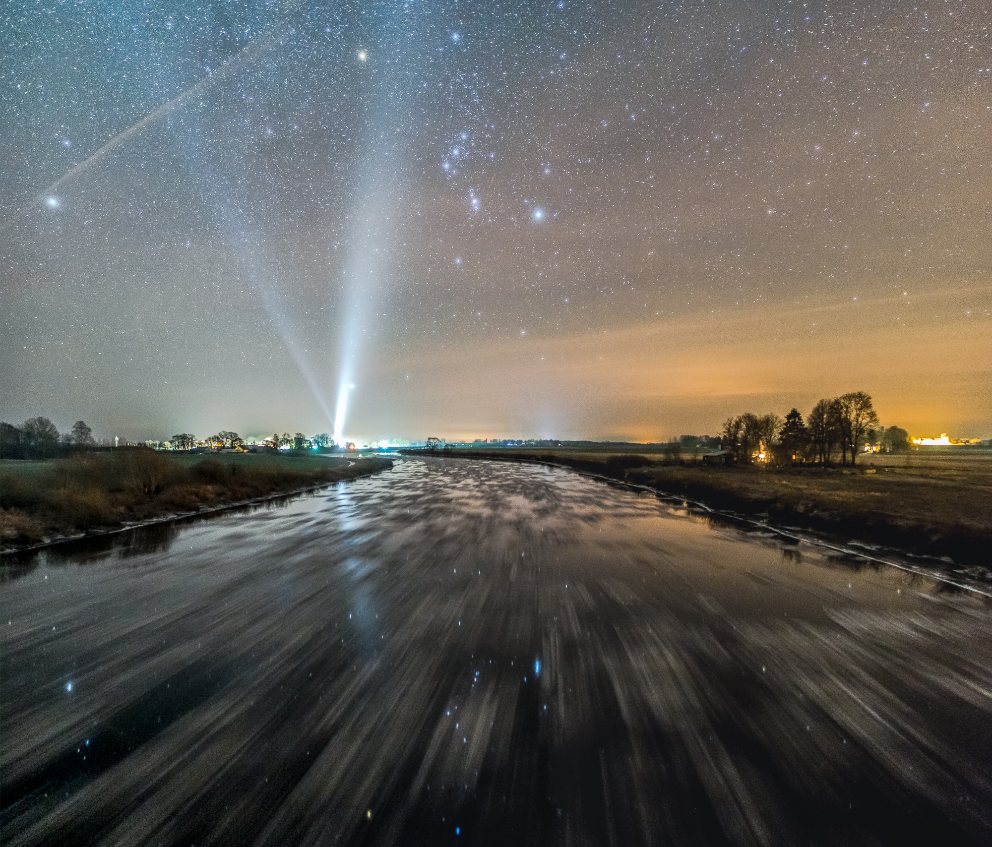 Ice is forming on the river Lielupe as it flows through the landscape in this winter's night scene. Even in motion the frigid water still reflects a starry sky, though. The well planned, Orion-centered panorama looks toward the south, taken in three exposures from a bridge near the village of Stalgene, Latvia, planet Earth. Drifting pancakes of ice leave streaks in the long exposures, while familiar stars of Orion and the northern winter night appear above and below the horizon. Village lights along the horizon include skyward beams from the local community church. This image was a first place winner in the 2018 StarSpace astrophotography competition.