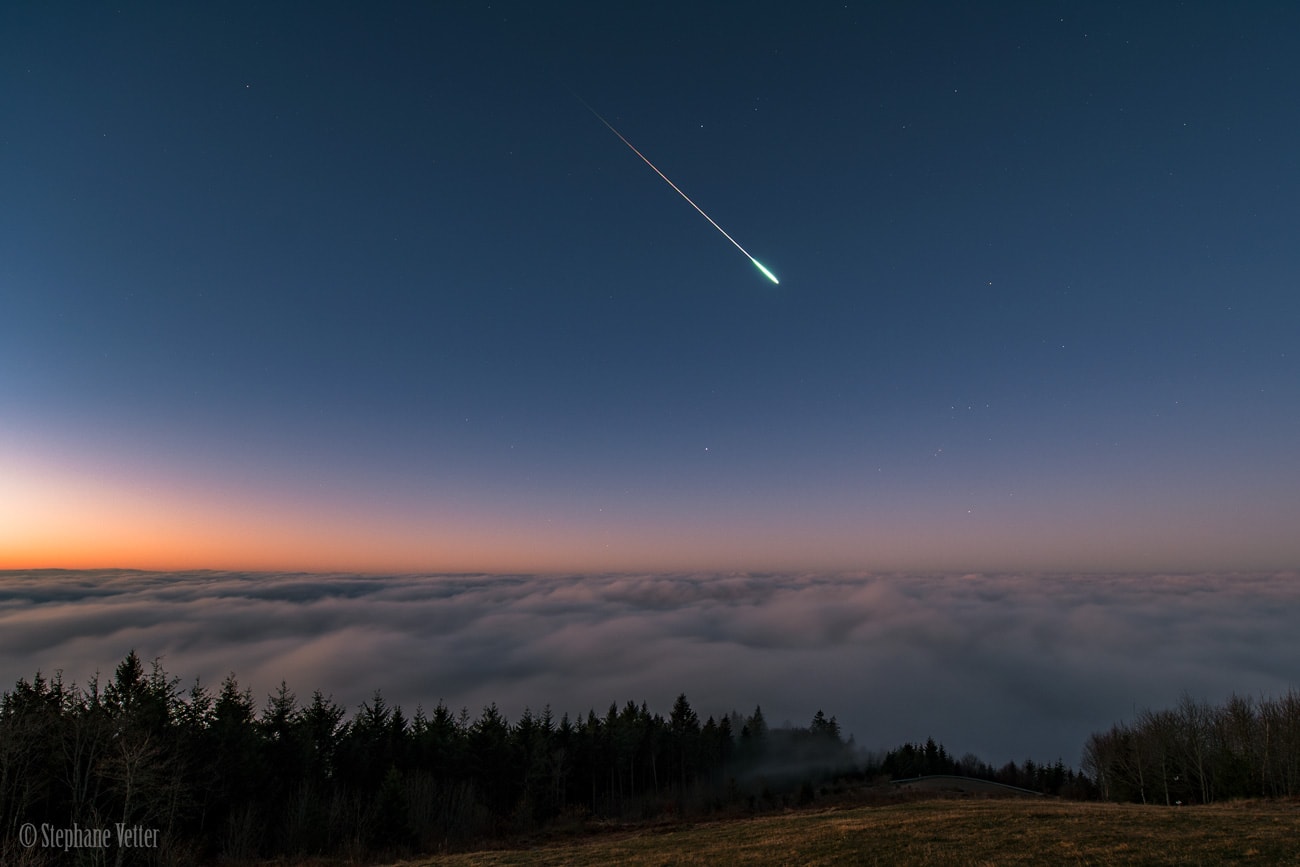 On November 17, just an hour before sunrise, this bright and colorful meteor flashed through clear predawn skies. Above a sea of clouds this striking autumn morning's moment was captured from Hochblauen, a prominent 1165 meter high summit in southern Germany's Black Forest. Shining through the twilight, Sirius as well as the familiar stars of Orion are recognizable near the southwestern horizon, and the meteor seems headed right for the hunter's belt and sword. Still, as part of the annual Leonid meteor shower, the meteor trail does point back to the shower's radiant. The constellation Leo is high above the horizon and off the top left of the frame.