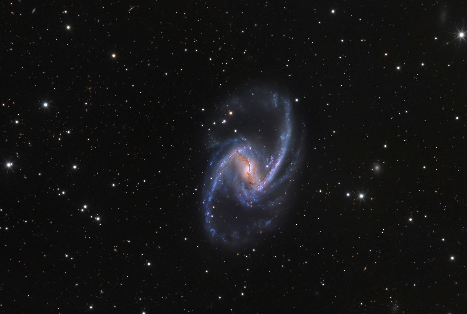 Barred spiral galaxy NGC 1365 is truly a majestic island universe some 200,000 light-years across. Located a mere 60 million light-years away toward the chemical constellation Fornax, NGC 1365 is a dominant member of the well-studied Fornax galaxy cluster. This impressively sharp color image shows intense star forming regions at the ends of the bar and along the spiral arms, and details of dust lanes cutting across the galaxy's bright core. At the core lies a supermassive black hole. Astronomers think NGC 1365's prominent bar plays a crucial role in the galaxy's evolution, drawing gas and dust into a star-forming maelstrom and ultimately feeding material into the central black hole.