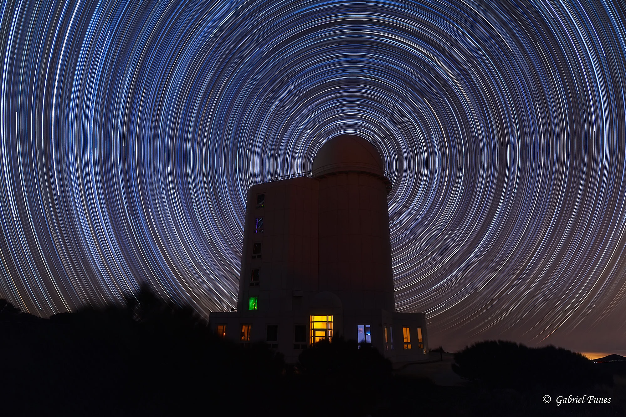 As Earth spins on its axis, the stars appear to rotate around an observatory in this well-composed image from the Canary Island of Tenerife. Of course, the colorful concentric arcs traced out by the stars are really centered on the planet's North Celestial Pole. Convenient for northern hemisphere astro-imagers and celestial navigators alike, bright star Polaris is near the pole and positioned in this scene to be behind the telescope dome. Made with a camera fixed to a tripod, the series of over 200 stacked digital exposures spanned about 4 hours. The observatory was not operating on that clear, dark night, but that's not surprising. The dome houses the Teide Observatory's large THEMIS Solar Telescope.