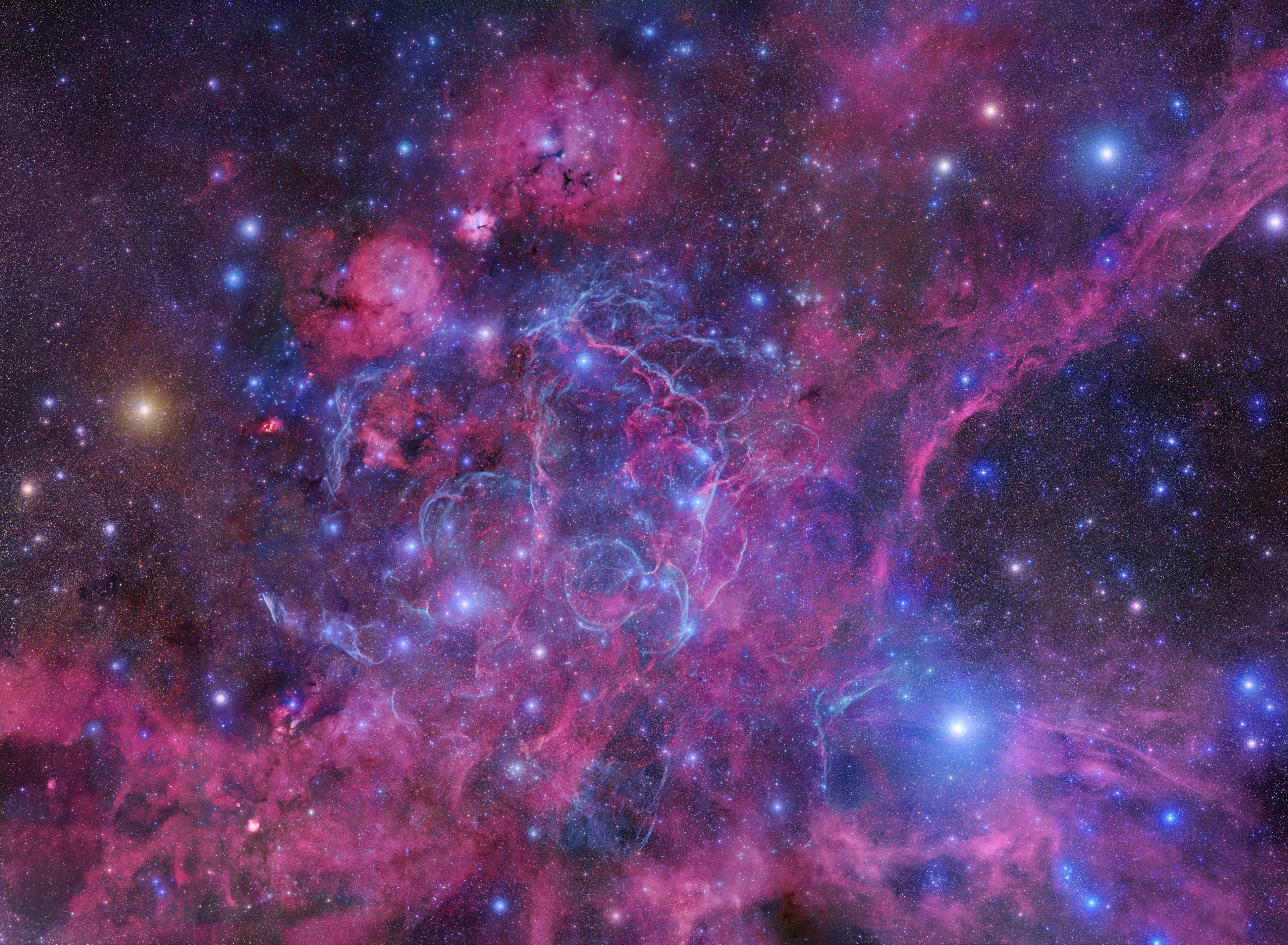 The plane of our Milky Way Galaxy runs through this complex and beautiful skyscape. Seen toward colorful stars near the northwestern edge of the constellation Vela (the Sails), the 16 degree wide, 200 frame mosaic is centered on the glowing filaments of the Vela Supernova Remnant, the expanding debris cloud from the death explosion of a massive star. Light from the supernova explosion that created the Vela remnant reached Earth about 11,000 years ago. In addition to the shocked filaments of glowing gas, the cosmic catastrophe also left behind an incredibly dense, rotating stellar core, the Vela Pulsar. Some 800 light-years distant, the Vela remnant is likely embedded in a larger and older supernova remnant, the Gum Nebula. Objects identified in this broad mosaic include emission and reflection nebulae, star clusters, and the remarkable Pencil Nebula.