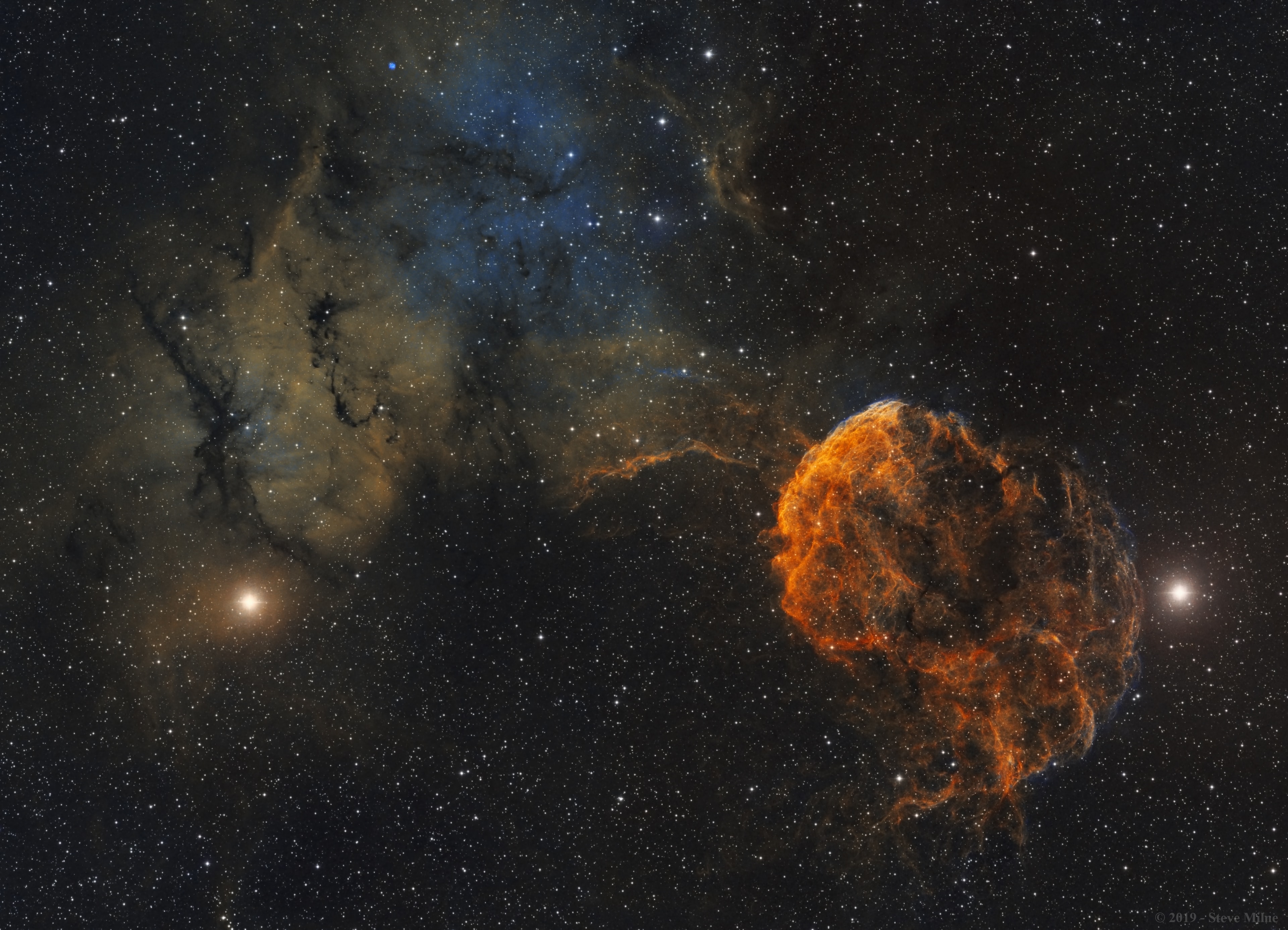Normally faint and elusive, the Jellyfish Nebula is caught in this alluring telescopic field of view. The entire scene is a two panel mosaic constructed using narrowband image data, with emission from sulfur, hydrogen and oxygen atoms shown in red, green and blue hues. It's anchored right and left by two bright stars, Mu and Eta Geminorum, at the foot of the celestial twin. The Jellyfish Nebula itself is right of center, the brighter arcing ridge of emission with dangling tentacles. In fact, the cosmic jellyfish is part of bubble-shaped supernova remnant IC 443, the expanding debris cloud from a massive star that exploded. Light from the explosion first reached planet Earth over 30,000 years ago. Like its cousin in astrophysical waters the Crab Nebula supernova remnant, the Jellyfish Nebula is known to harbor a neutron star, the remnant of the collapsed stellar core. An emission nebula cataloged as Sharpless 249 fills the field at the upper left. The Jellyfish Nebula is about 5,000 light-years away. At that distance, this image would be about 300 light-years across.