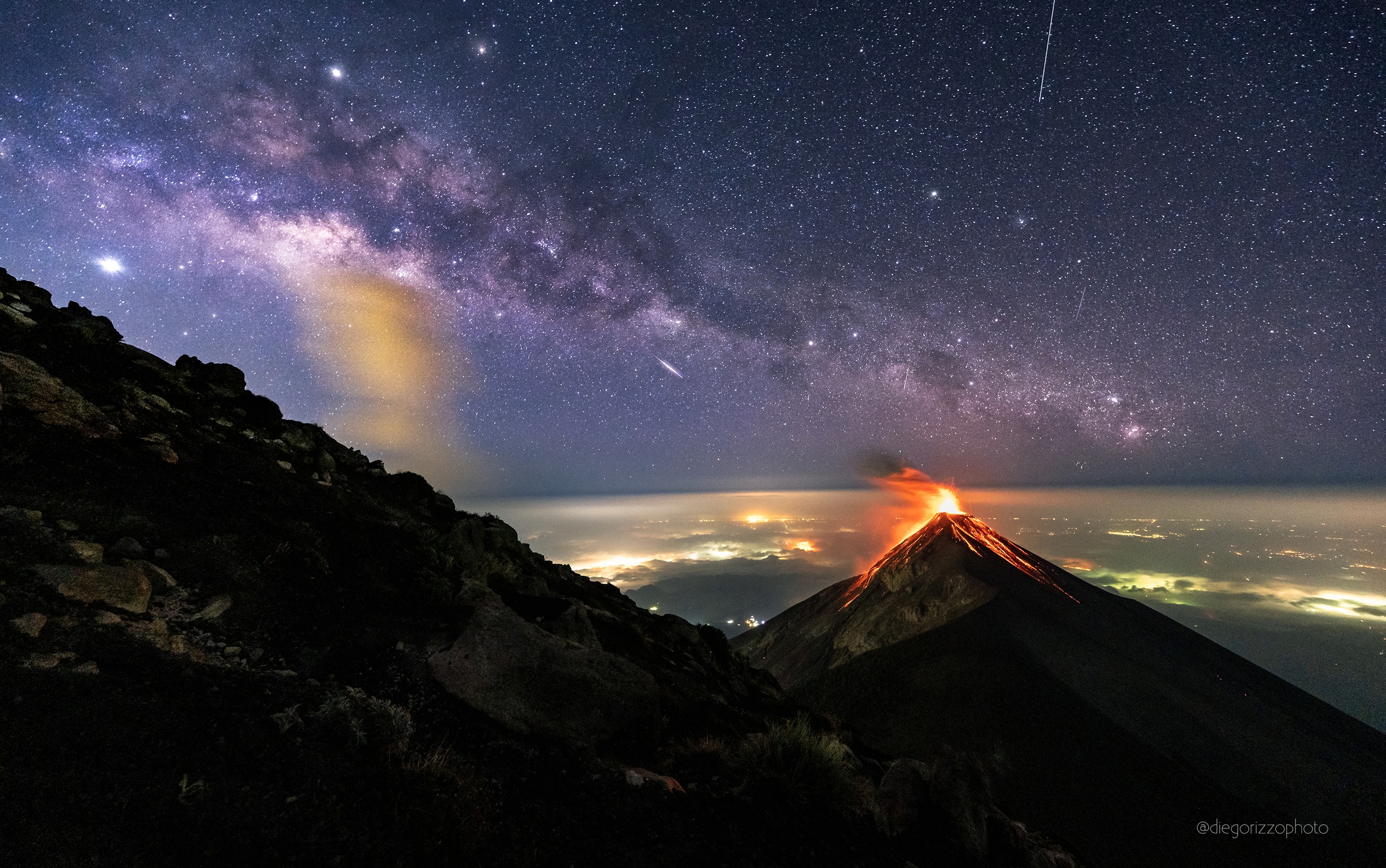 Sometimes it's hard to decide which is more impressive -- the land or the sky. On the land of the featured image, for example, the Volcano of Fire (Volc�n de Fuego) is seen erupting topped by red-hot, wind-blown ash and with streams of glowing lava running down its side. Lights from neighboring towns are seen through a thin haze below. In the sky, though, the central plane of our Milky Way Galaxy runs diagonally from the upper left, with a fleeting meteor just below, and the trail of a satellite to the upper right. The planet Jupiter also appears toward the upper left, with the bright star Antares just to its right. Much of the land and the sky were captured together in a single, well-timed, 25-second exposure taken in mid-April from the side of Fuego's sister volcano Acatenango in Guatemala. The image of the meteor, though, was captured in a similar frame taken about 30 minutes earlier -- when the volanic eruption was not as photogenic -- and added later digitally. Follow APOD on: Instagram, Facebook, Reddit, or Twitter