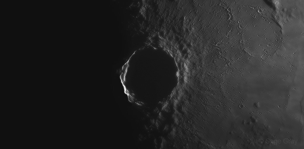 A prominent impact site anchored in the lunar Oceanus Procellarum, Copernicus crater is at the center of this telescopic portrait in light and shadow. Caught in stacked and sharpened video frames recorded on April 14 at 3:30am UTC, the lunar terminator, or boundary between night and day, cuts across the middle of the 93 kilometer diameter crater. Sunlight is just beginning to strike its tall western walls but doesn't yet shine on lower terrain nearby, briefly extending the crater's outline into the lunar nightside. At that moment standing at Copernicus crater you could watch the sunrise, an event that happens at Copernicus every 29.5 days. Of course that corresponds to a lunar month or a lunation, the time between consecutive Full Moons as seen from planet Earth.