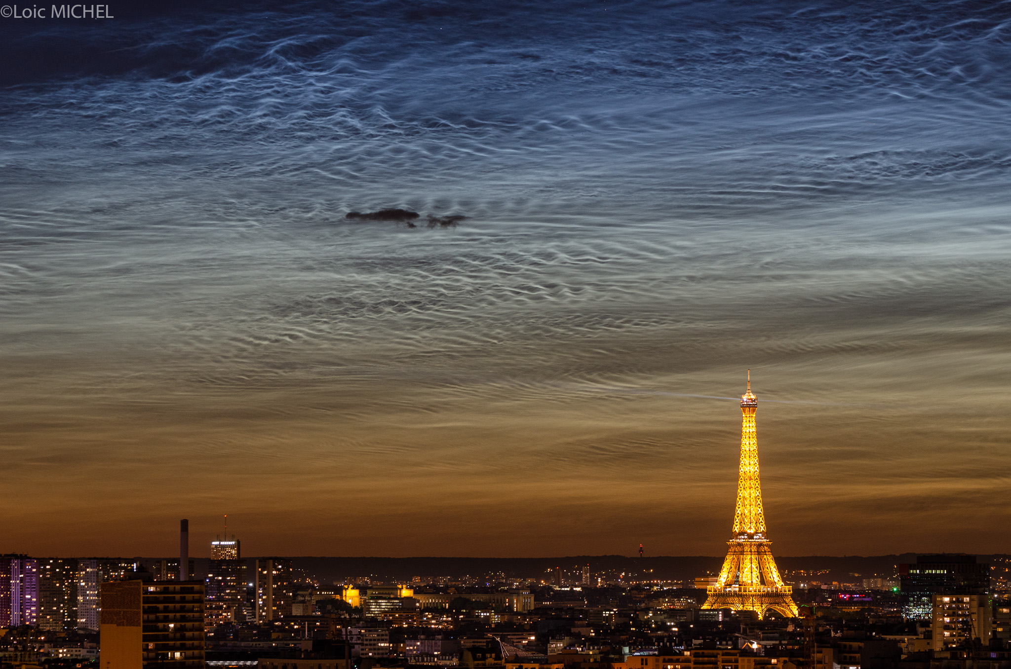 The night of June 21 was the shortest night for planet Earth's northern latitudes, so at latitude 48.9 degrees north, Paris was no exception. Still, the City of Light had an exceptionally luminous evening. Its skies were flooded with silvery night shining or noctilucent clouds after the solstice sunset. Hovering at the edge of space, the icy condensations on meteoric dust or volcanic ash are still in full sunlight at the extreme altitudes of the mesophere. Seen at high latitudes in summer months, stunning, wide spread displays of northern noctilucent clouds are now being reported.