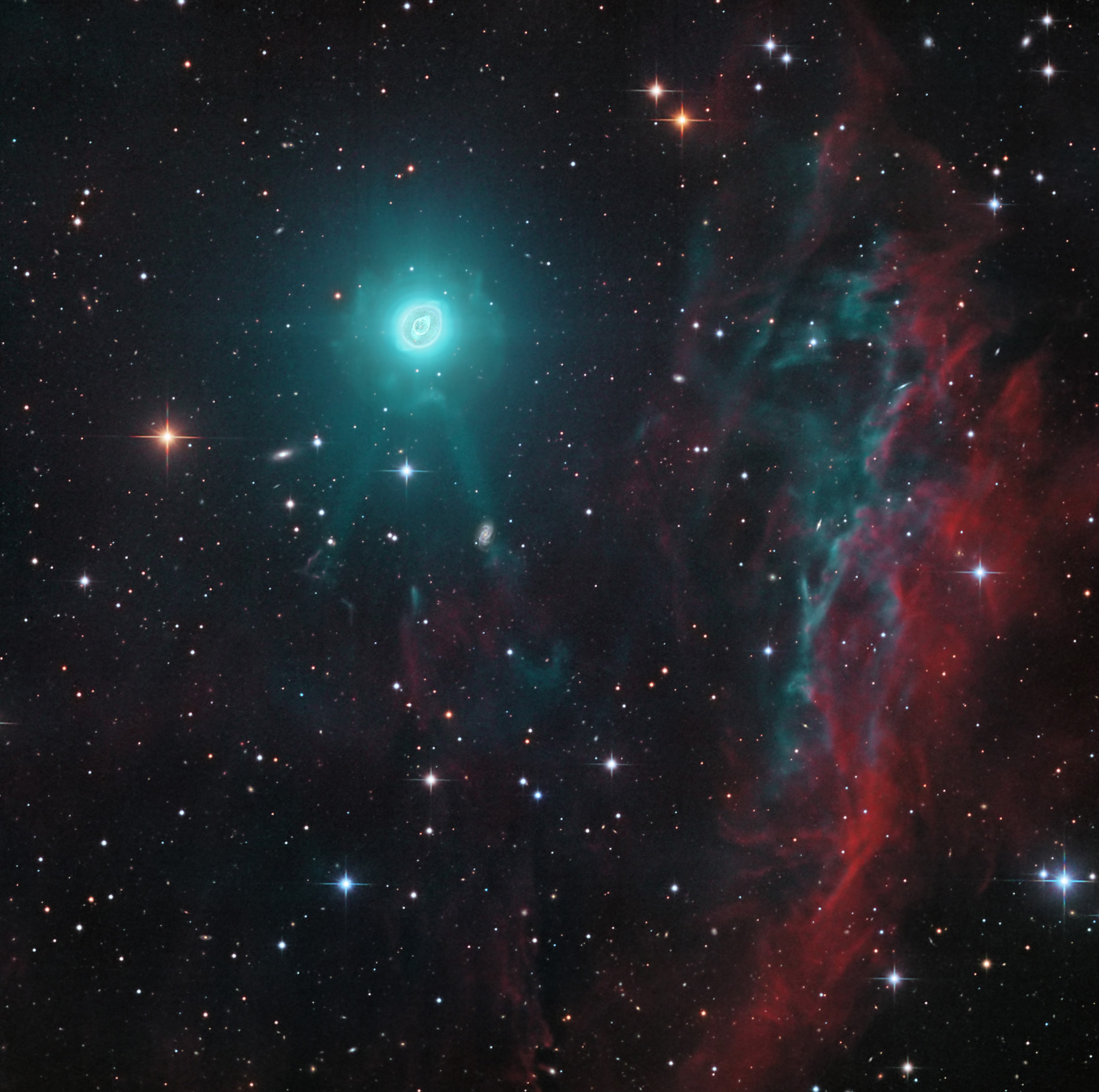 Close-up images of NGC 3242 show the cast off shroud of a dying, sun-like star fancifully known as The Ghost of Jupiter nebula. But this deep and wide telescopic view also finds the seldom seen outer halo of the beautiful planetary nebula at the upper left, toward Milky Way stars and background galaxies in the serpentine constellation Hydra. Intense and otherwise invisible ultraviolet radiation from the nebula's central white dwarf star powers its illusive glow in visible light. In fact, planets of NGC 3242's evolved white dwarf star may have contributed to the nebula's symmetric features and shape. Activity beginning in the star's red giant phase, long before it produced a planetary nebula, is likely the cause of the fainter more extensive halo. About a light-year across NGC 3242 is some 4,500 light-years away. The tenuous clouds of glowing material at the right could well be interstellar gas, by chance close enough to the NGC 3242's white dwarf to be energized by its ultraviolet radiation.