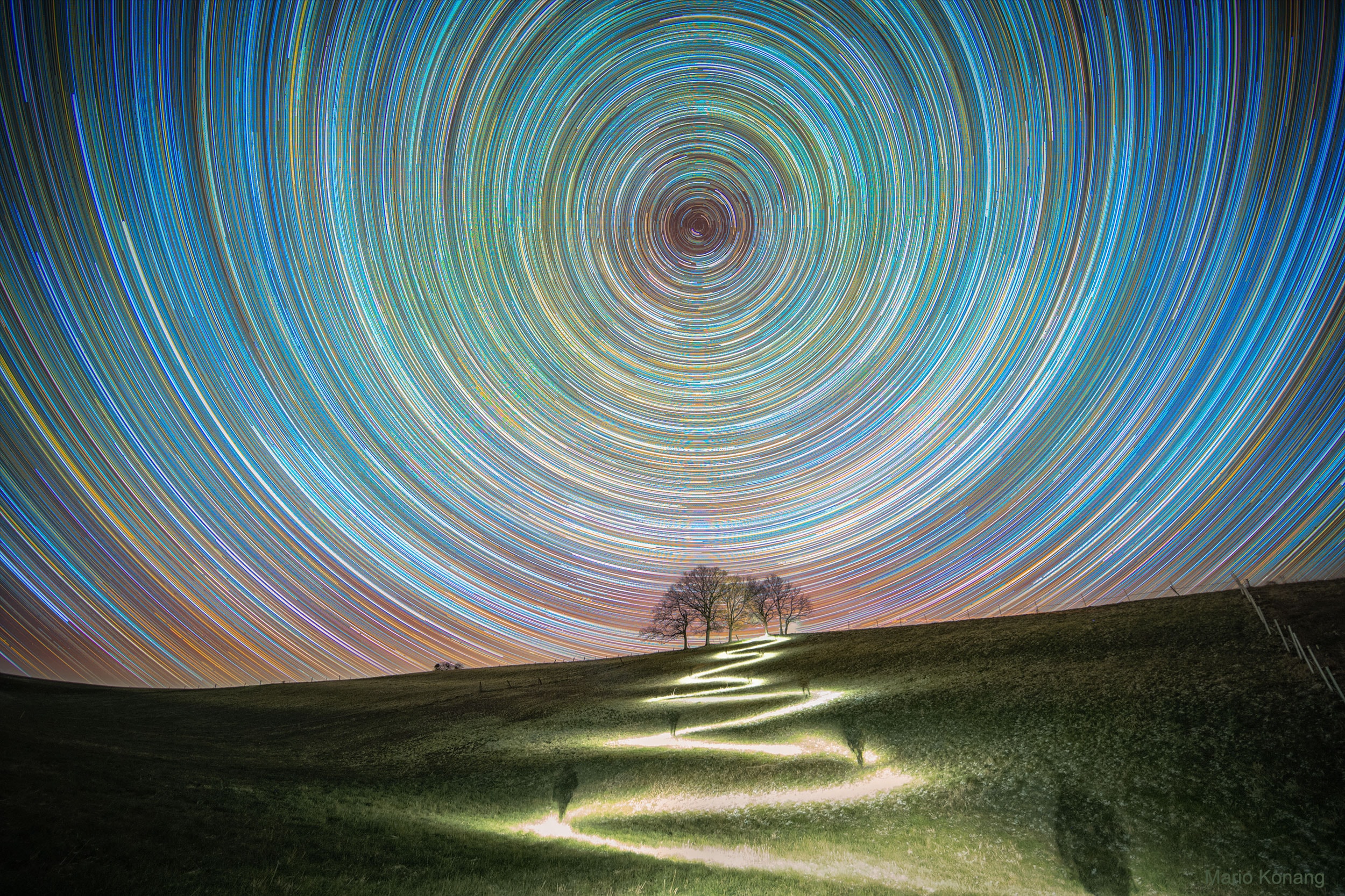 What happens if you keep going north? The direction north on the Earth, the place on your horizon below the northern spin pole of the Earth -- around which other stars appear to slowly swirl, will remain the same. This spin-pole-of-the-north will never move from its fixed location on the sky -- night or day -- and its height will always match your latitude. The further north you go, the higher the north spin pole will appear. Eventually, if you can reach the Earth's North Pole, the stars will circle a point directly over your head. Pictured, a four-hour long stack of images shows stars trailing in circles around this north celestial pole. The bright star near the north celestial pole is Polaris, known as the North Star. The bright path was created by the astrophotographer's headlamp as he zigzagged up a hill just over a week ago in Lower Saxony, Germany. The astrophotographer can be seen, at times, in shadow. Actually, the Earth has two spin poles -- and much the same would happen if you started below the Earth's equator and went south.