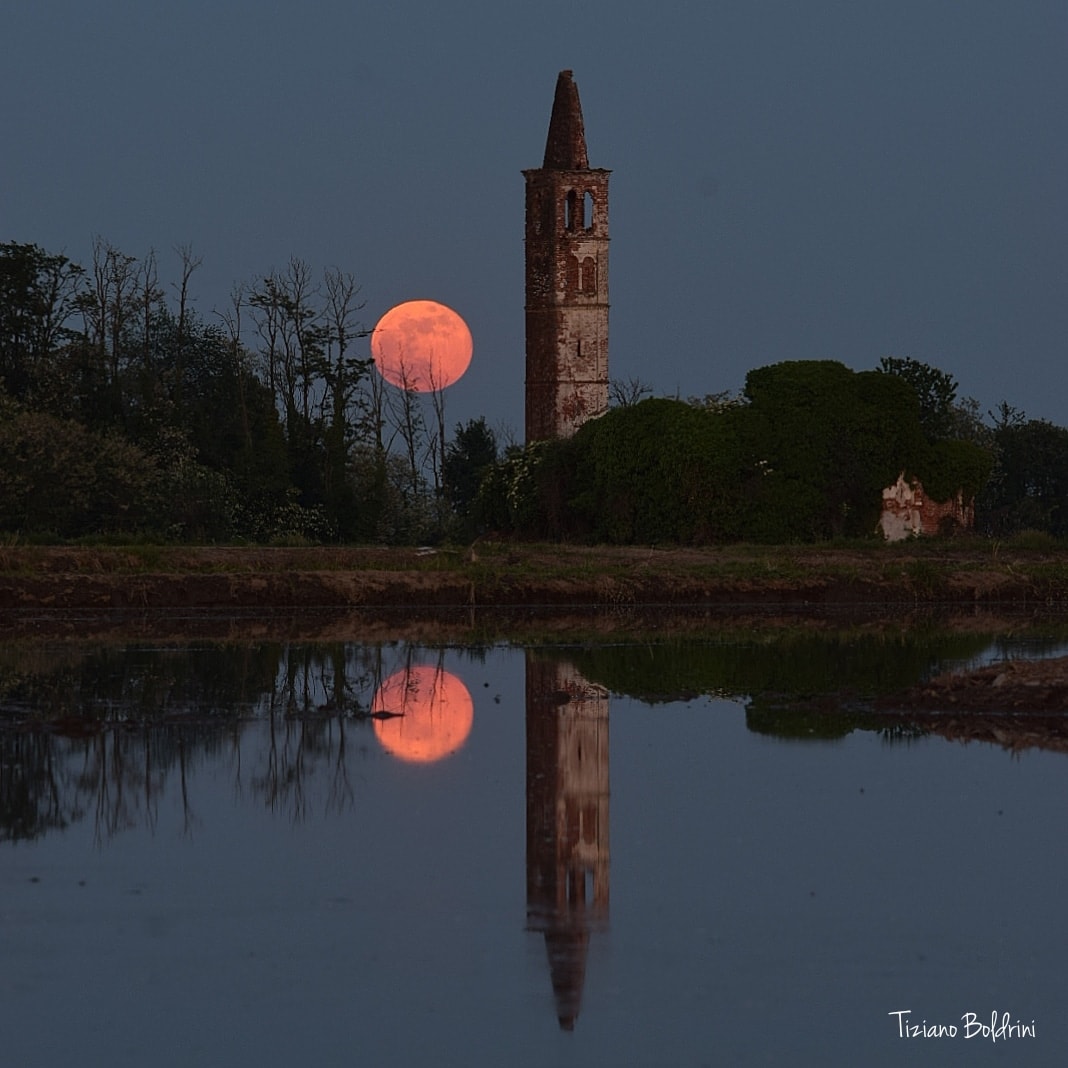 Rising as the Sun set, the Moon was bright and full in planet Earth skies on May 7 and known to some as a Flower Moon. Near the horizon it does seem to take on rose pink hues of reddened sunlight in this reflective twilight scene. In fact one of the brighter Full Moons of the year, this month's full lunar phase occurred within about 32 hours of perigee. That's the closest point in the Moon's elliptical orbit. Flooded field and ruined church tower are near the municipality of Casaleggio Novara, Piedmont Region of northern Italy.