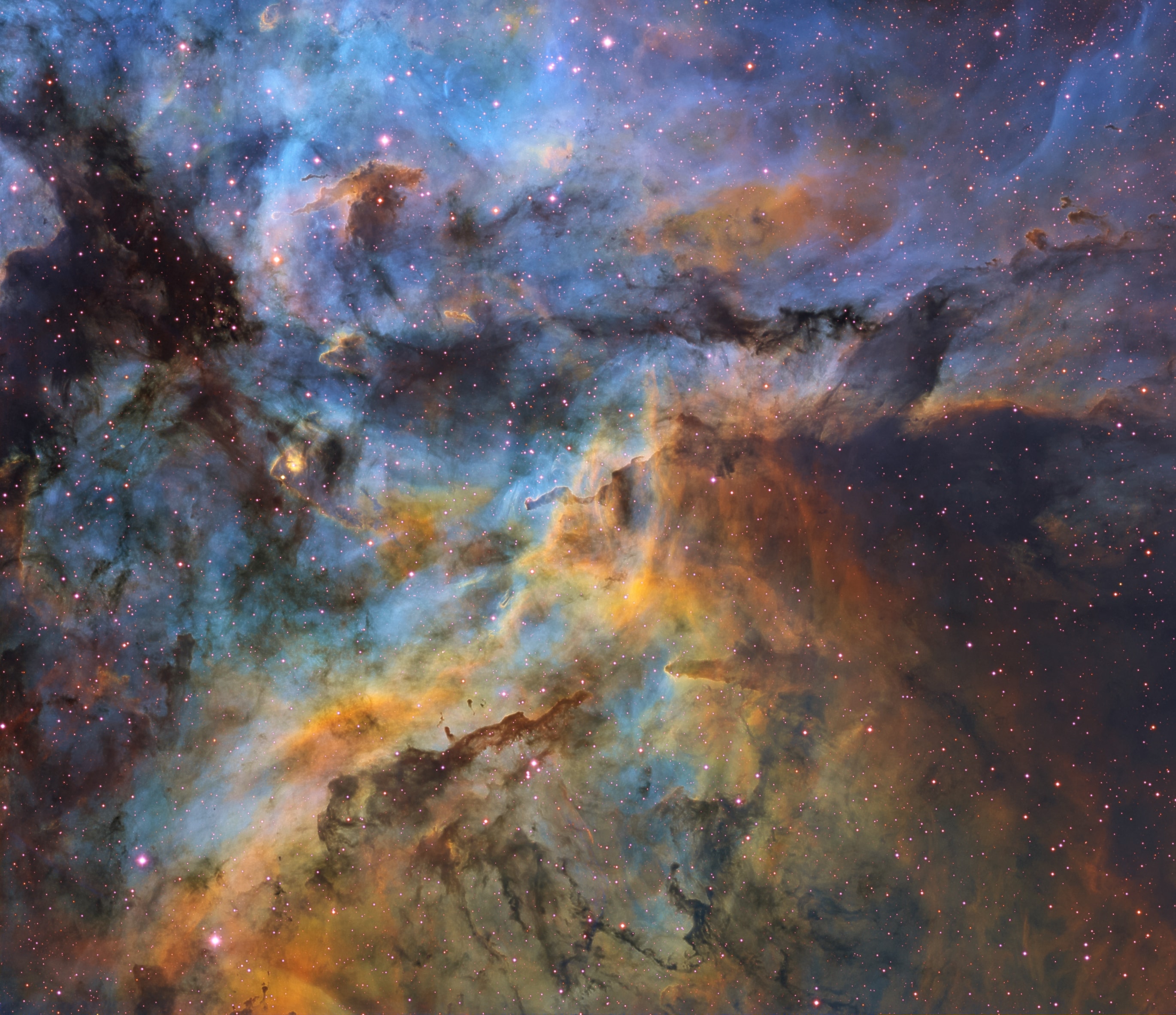 With natal dust clouds in silhouette against glowing atomic gas, this colorful and chaotic vista lies within one of the largest star forming regions in the Milky Way galaxy, the Great Carina Nebula. The telescopic close-up frames a field of view about 80 light-years across, a little south and east of Eta Carinae, the nebula's most energetic and enigmatic star. Captured under suburban skies improved during national restrictions, a composite of narrowband image data was used to create the final image. In it, characteristic emission from the nebula's ionized sulfur, hydrogen, and oxygen atoms is mapped to red, green, and blue hues, a color palette also popular in Hubble Space Telescope images. The celestial landscape of bright ridges of emission bordered by cool, obscuring dust lies about 7,500 light-years away toward the southern constellation Carina.