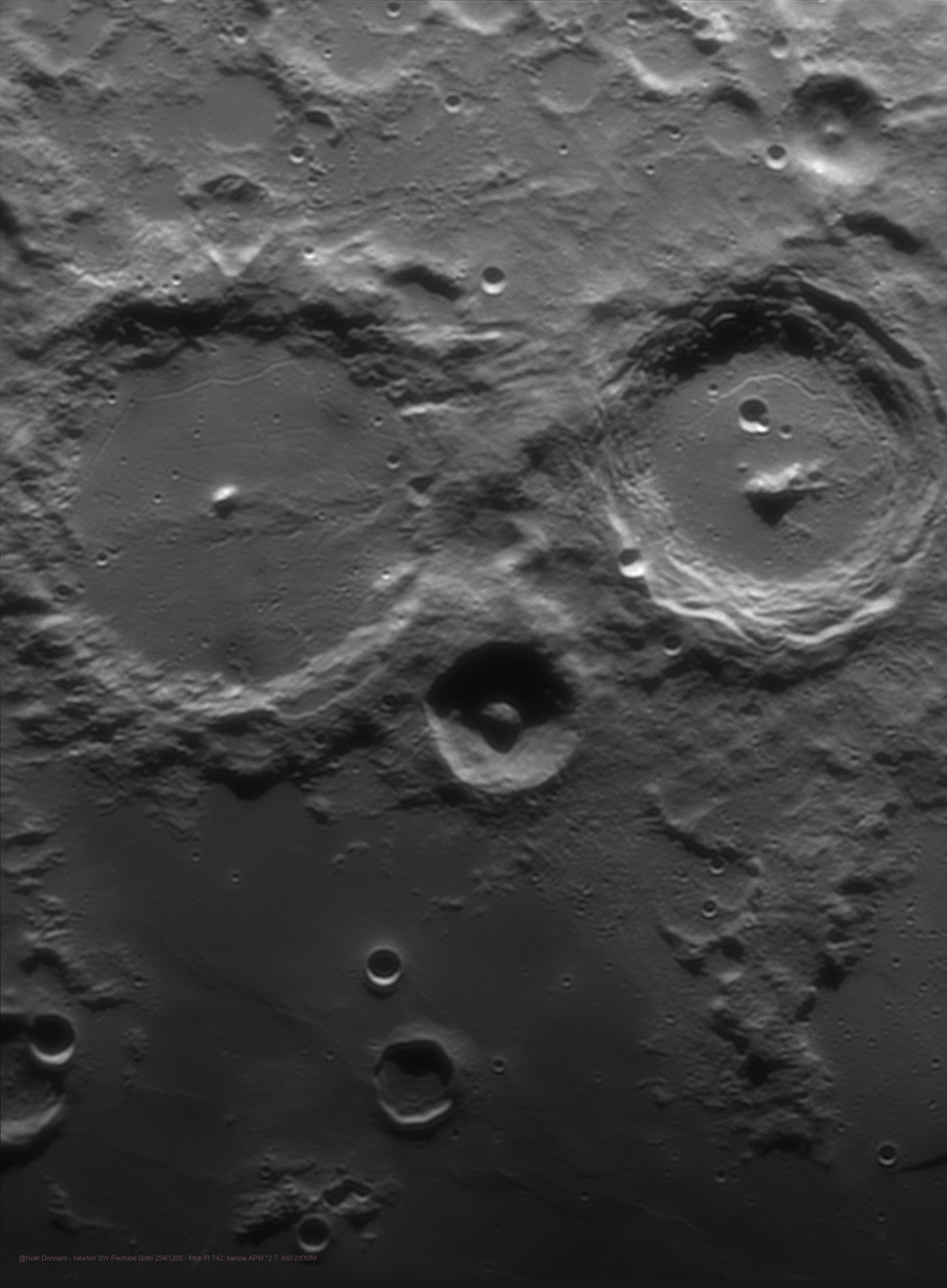 Point your telescope at tonight's first quarter Moon. Along the terminator, the shadow line between night and day, you might find these two large craters staring back at you with an owlish gaze. Alphonsus (left) and Arzachel are ancient impact craters on the north eastern shores of Mare Nubium, the lunar Sea of Clouds. The larger Alphonsus is over 100 kilometers in diameter. A low sun angle highlights the crater's sharp 1.5 kilometer high central peak in bright sunlight and dark shadow. Scouting for potential Apollo moon landing sites, the Ranger 9 spacecraft returned closeup pictures of Alphonsus before crashing in the crater just northeast (toward the upper left) of its central mountain in 1965. Alpetragius, between Alphonsus and Arzachel, is the small crater with the deeply shadowed floor and overly large central beak.