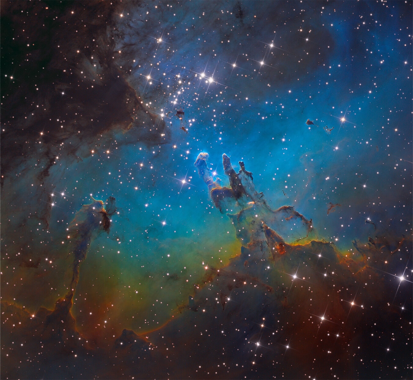 A star cluster around 2 million years young surrounded by natal clouds of dust and glowing gas, M16 is also known as The Eagle Nebula. This beautifully detailed image of the region adopts the colorful Hubble palette and includes cosmic sculptures made famous in Hubble Space Telescope close-ups of the starforming complex. Described as elephant trunks or Pillars of Creation, dense, dusty columns rising near the center are light-years in length but are gravitationally contracting to form stars. Energetic radiation from the cluster stars erodes material near the tips, eventually exposing the embedded new stars. Extending from the ridge of bright emission left of center is another dusty starforming column known as the Fairy of Eagle Nebula. M16 lies about 7,000 light-years away, an easy target for binoculars or small telescopes in a nebula rich part of the sky toward the split constellation Serpens Cauda (the tail of the snake).
