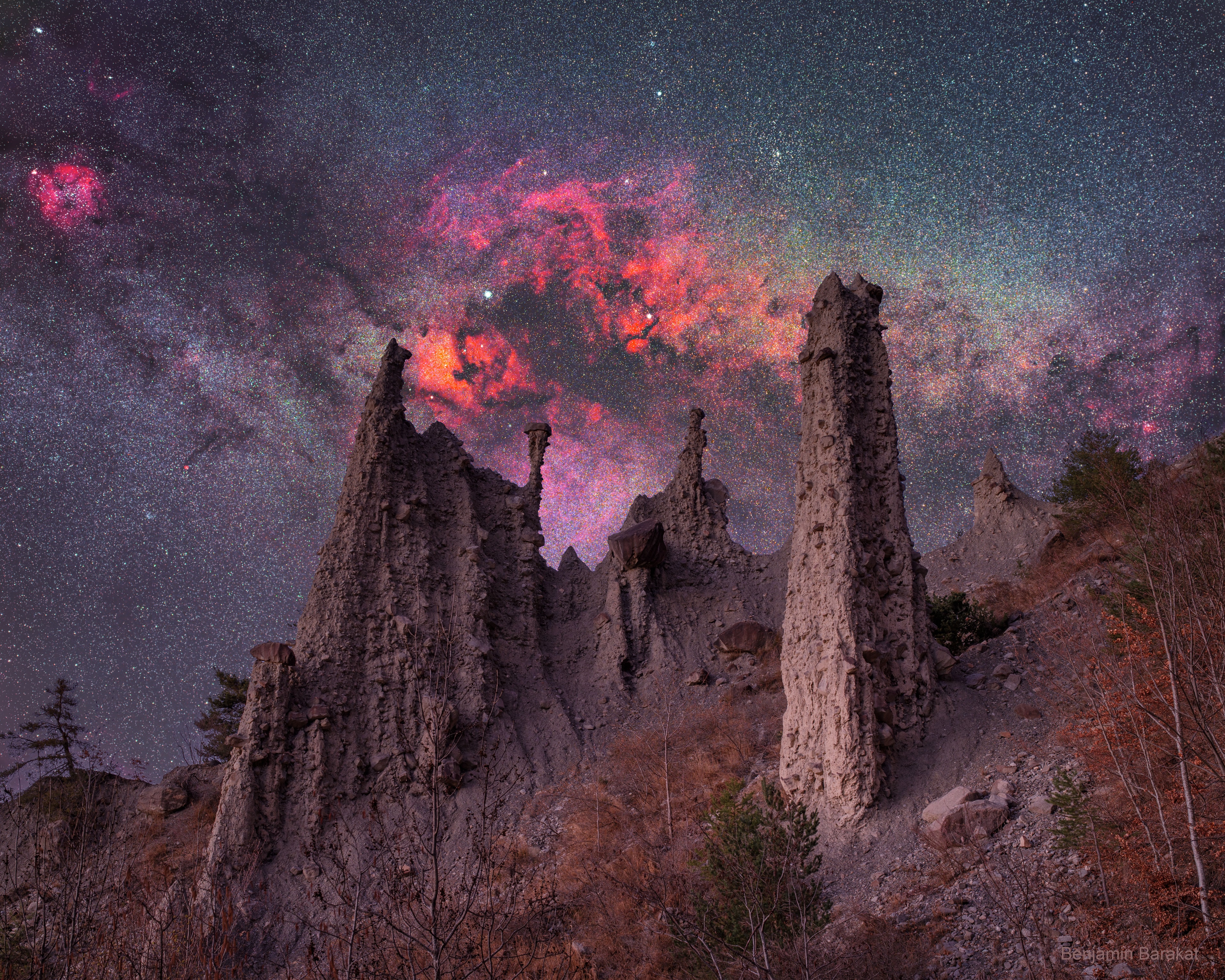 Real castles aren't this old. And the background galaxy is even older. Looking a bit like an alien castle, the pictured rock spires are called hoodoos and are likely millions of years old. Rare, but found around the world, hoodoos form when dense rocks slow the erosion of softer rock underneath. The pictured hoodoos survive in the French Alps and are named Demoiselles Coiffées -- which translates to English as "Ladies with Hairdos". The background galaxy is part of the central disk of our own Milky Way galaxy and contains stars that are typically billions of years old. The photogenic Cygnus sky region -- rich in dusty dark clouds and red glowing nebulas -- appears just above and behind the hoodoos. The featured image was taken in two stages: the foreground was captured during the evening blue hour, while the background was acquired from the same location later that night.
