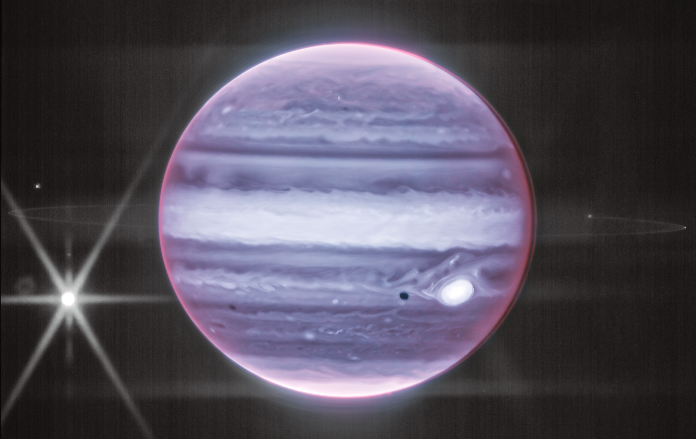 Why does Jupiter have rings? Jupiter's main ring was discovered in 1979 by NASA's passing Voyager 1 spacecraft, but its origin was then a mystery. Data from NASA's Galileo spacecraft that orbited Jupiter from 1995 to 2003, however, confirmed the hypothesis that this ring was created by meteoroid impacts on small nearby moons. As a small meteoroid strikes tiny Metis, for example, it will bore into the moon, vaporize, and explode dirt and dust off into a Jovian orbit. The featured image of Jupiter in infrared light by the James Webb Space Telescope shows not only Jupiter and its clouds, but this ring as well. Also visible is Jupiter's Great Red Spot (GRS) -- in comparatively light color on the right, Jupiter's large moon Europa -- in the center of diffraction spikes on the left, and Europa's shadow -- next to the GRS. Several features in the image are not yet well understood, including the seemingly separated cloud layer on Jupiter's right limb. Celestial Surprise: What picture did APOD feature on your birthday? (post 1995)